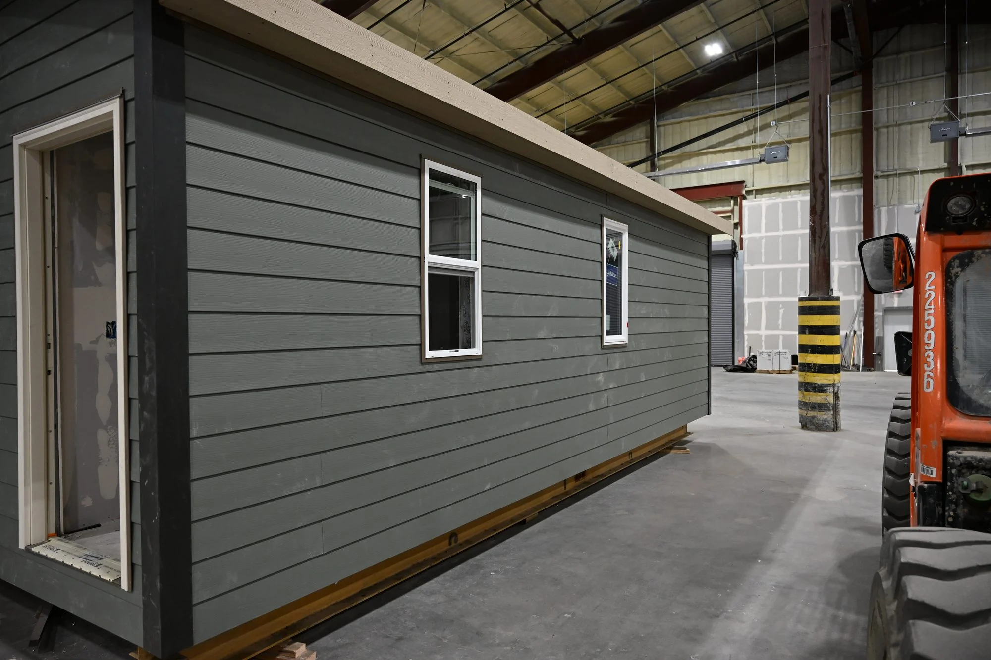 Cabin with gray lap siding during factory construction