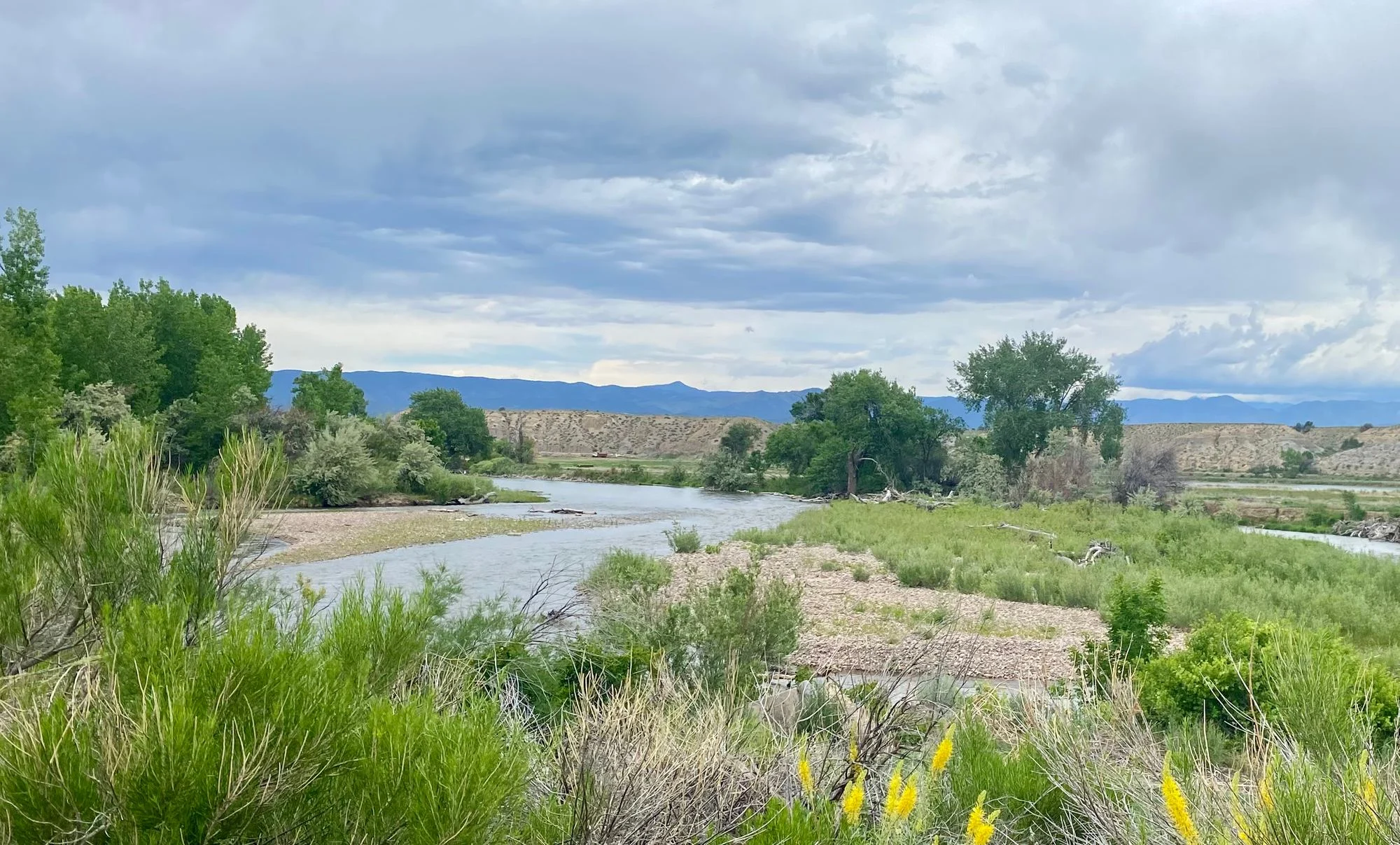 Arkansas River flowing beside the factory through a green valley