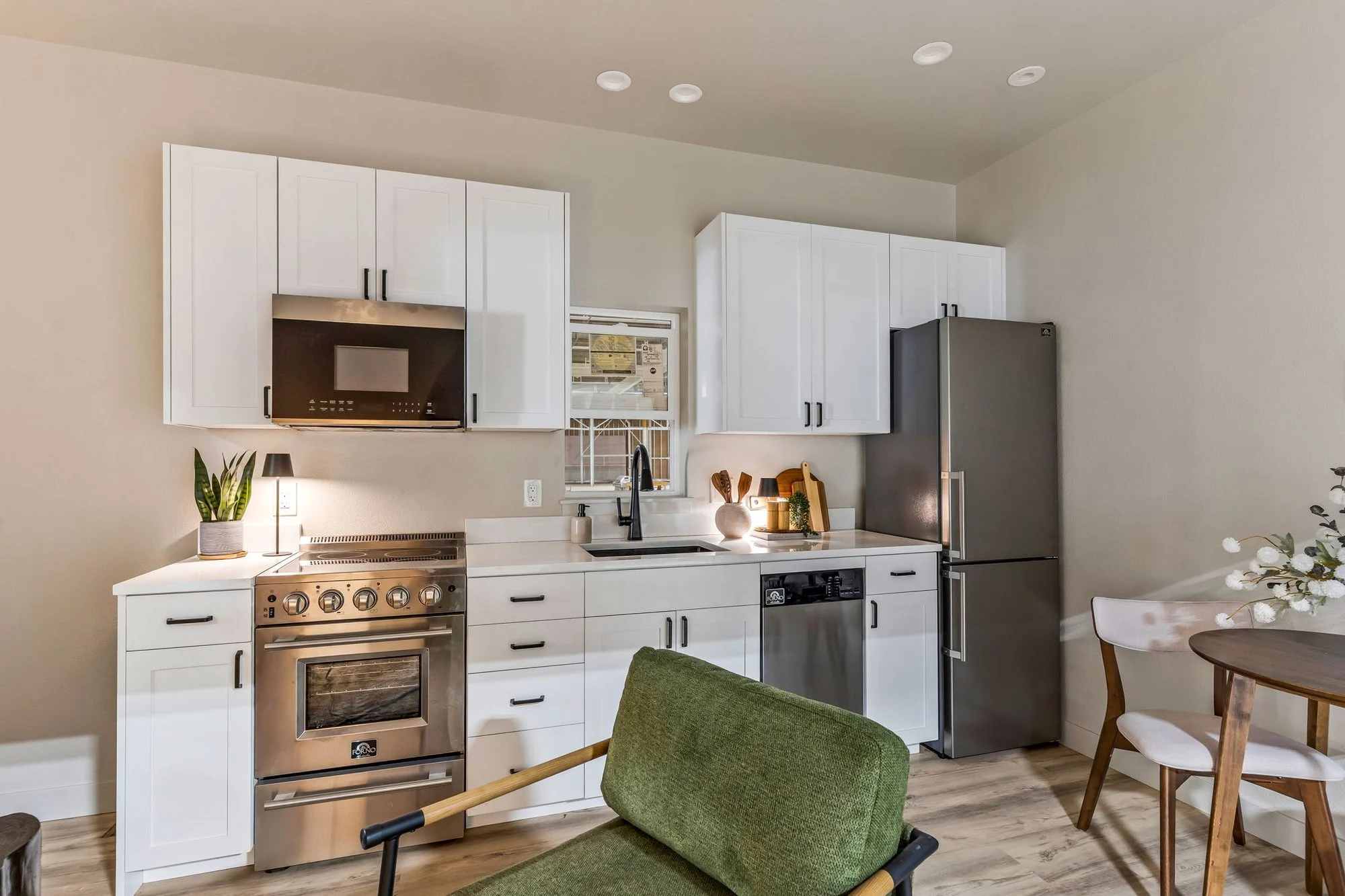 Basecamp kitchen with white cabinets and stainless steel appliances