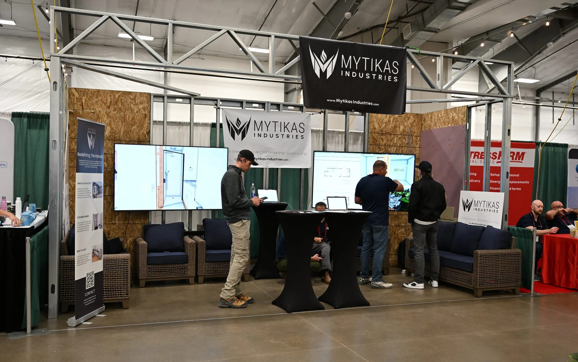 Mytikas steel-framed exhibition booth with cabin displays and banners at The Glamping Show