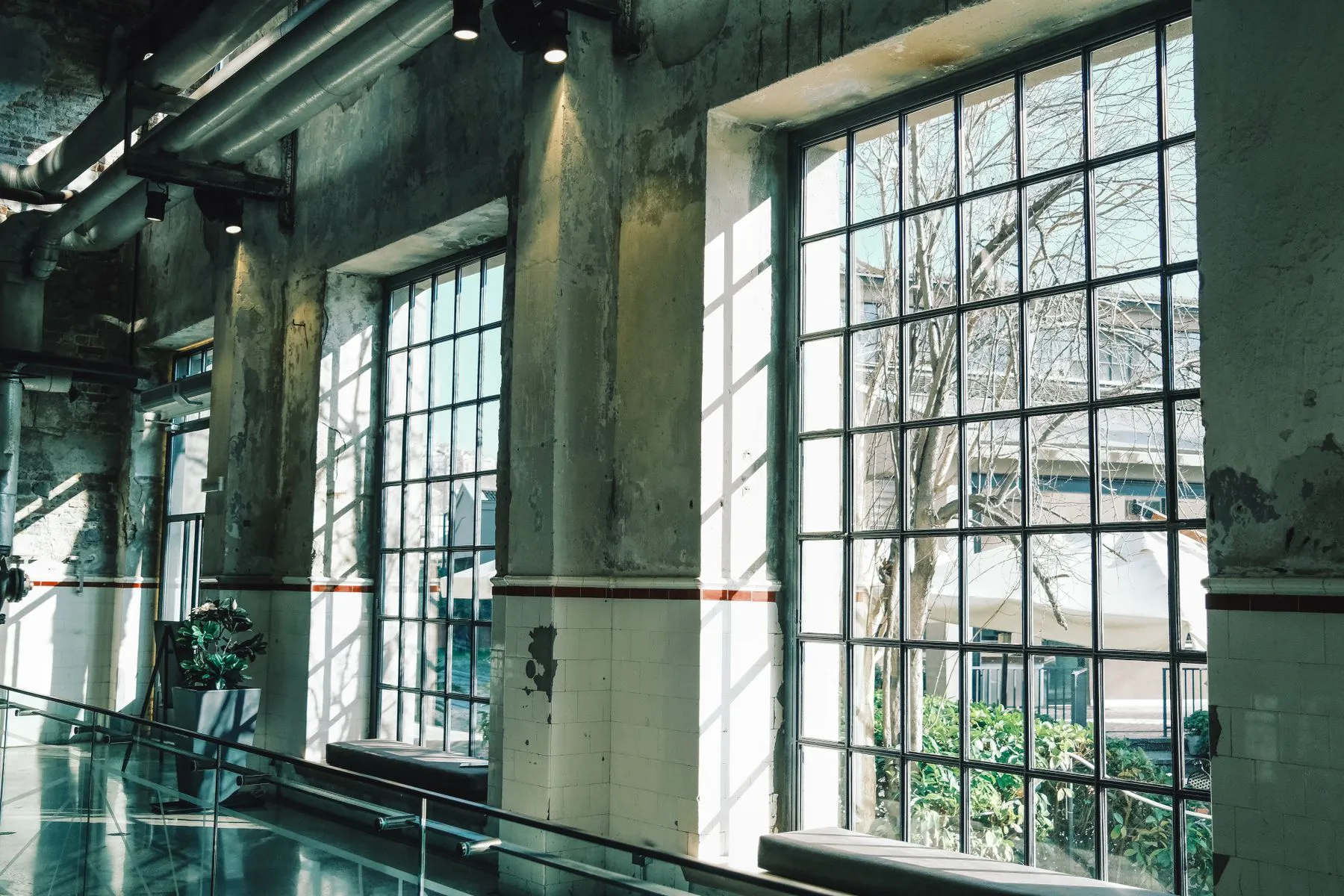 A sunlit people-free industrial workspace with large windows and connected infrastructure