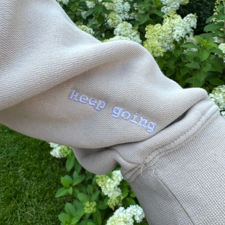 Sweatshirt sleeve highlighting our embroidery capabilities and custom designs.