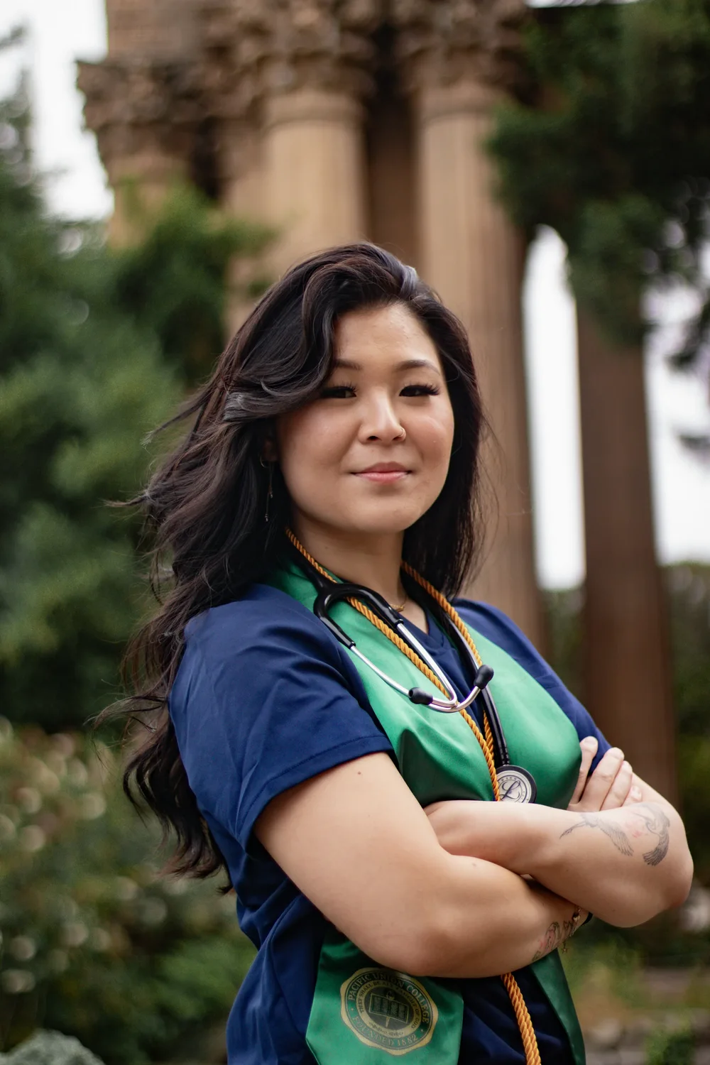 Sponsored scholar in nursing scrubs and graduation stole