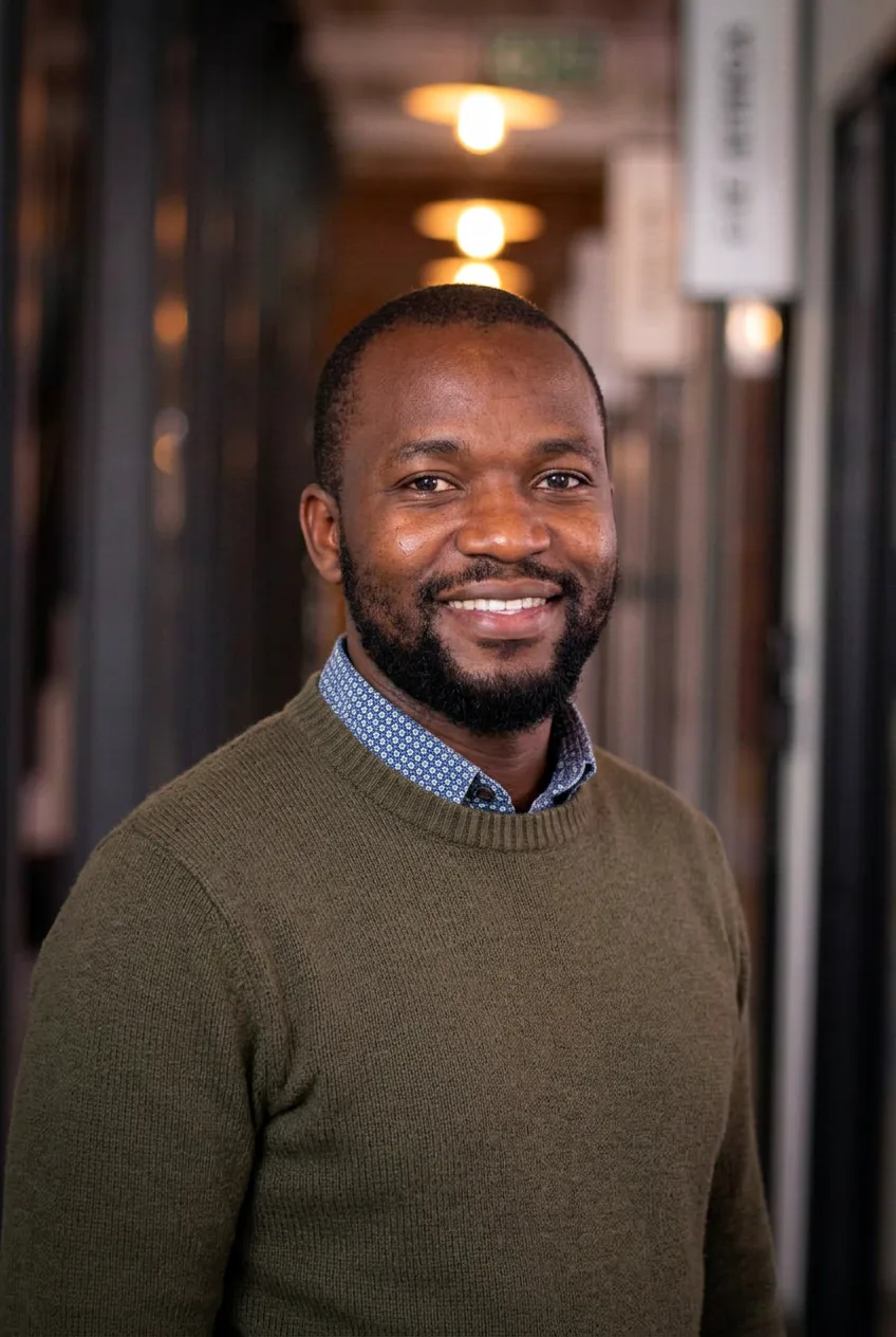 Founder in a green sweater at a cohort event, smiling