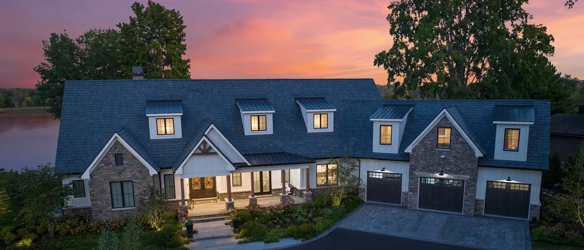 Lakeside home with a Brava Old World Slate roof at dusk