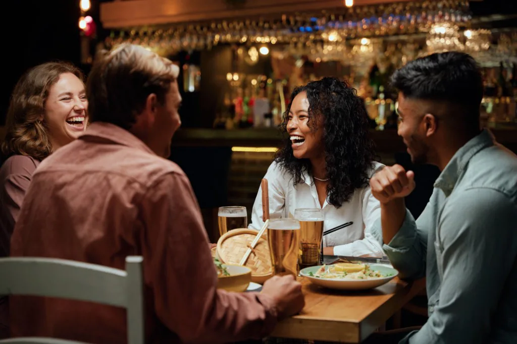 Friends laughing together over drinks