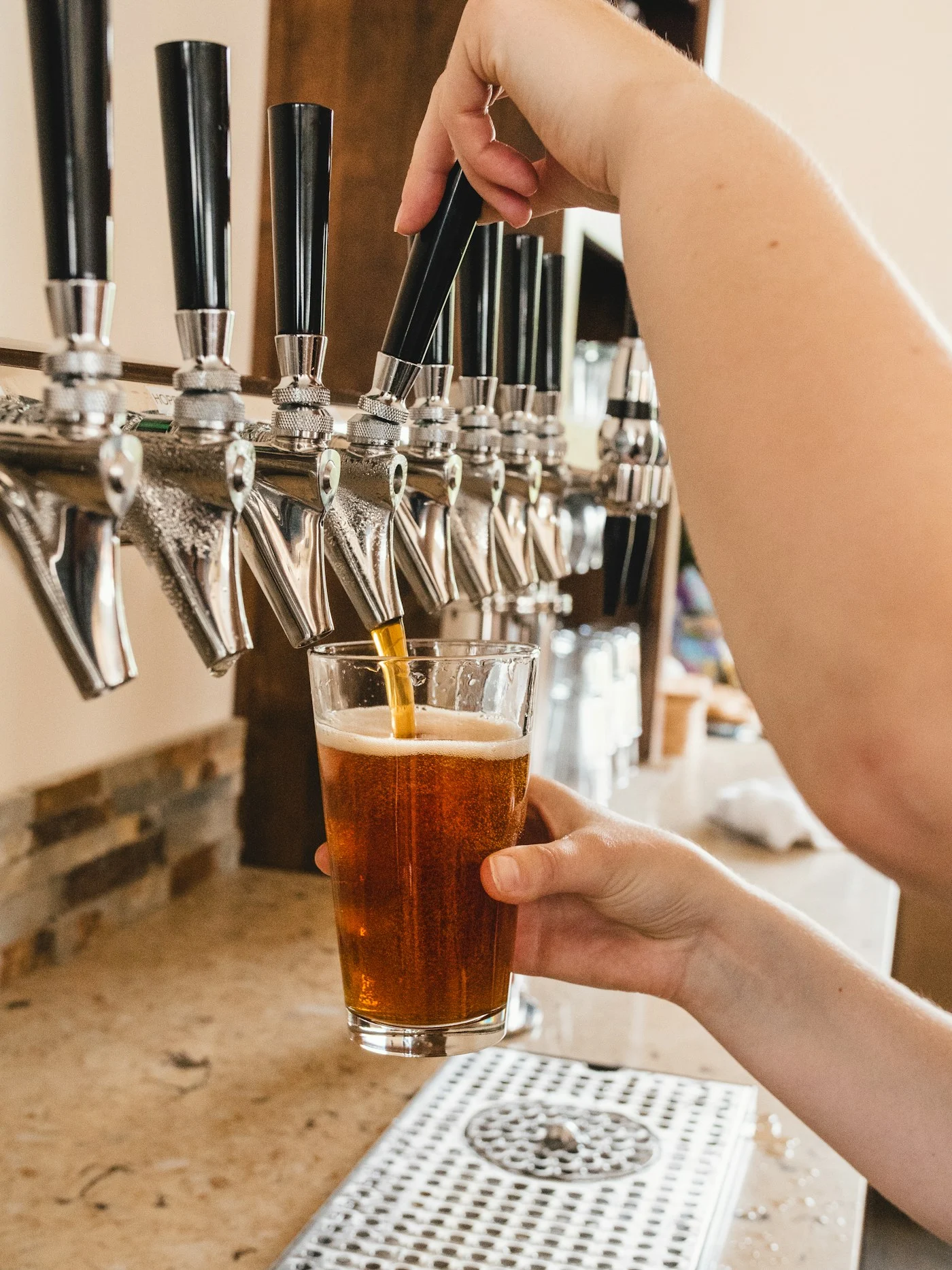 Illustrative photograph: amber beer being poured from an unmarked tap into a glass