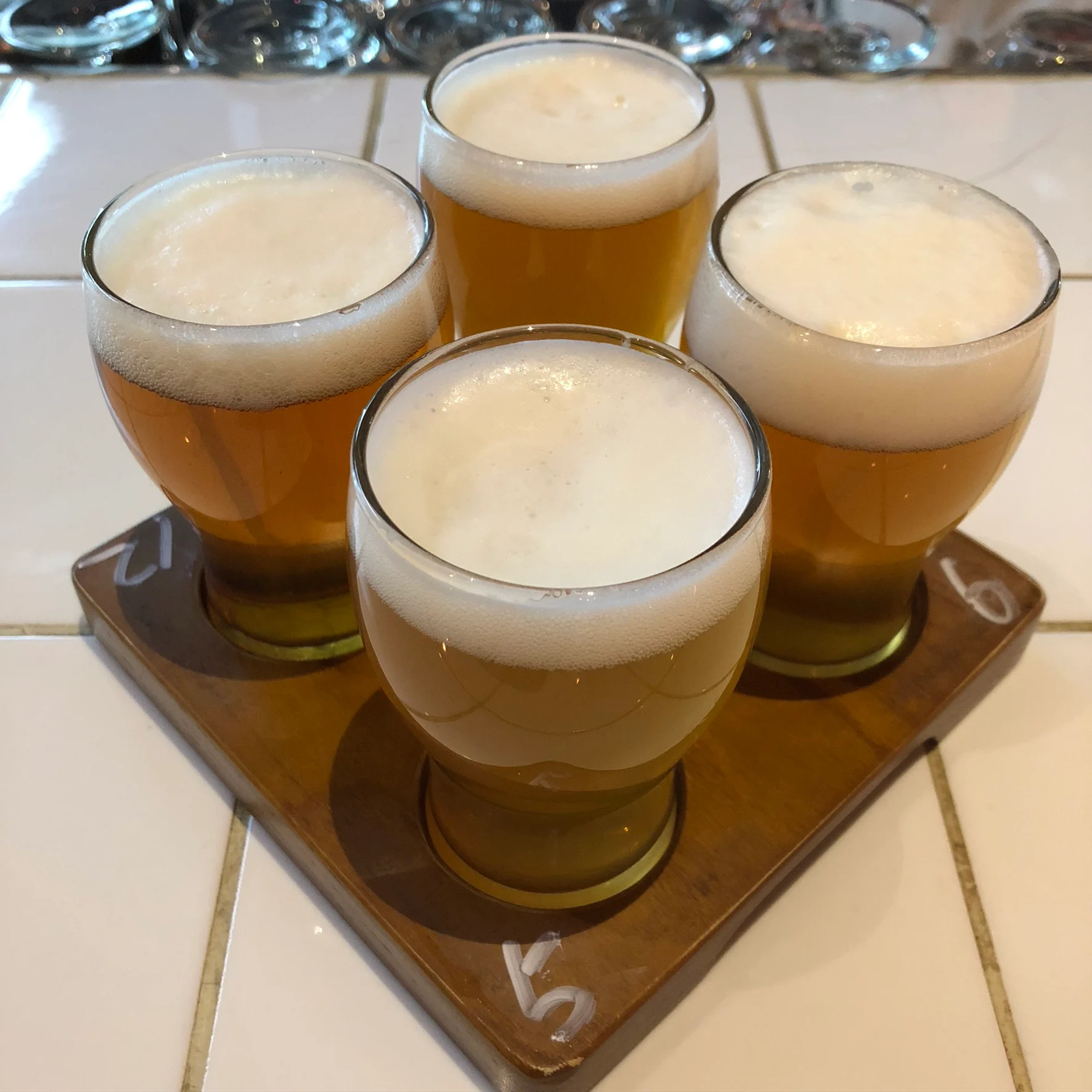 Illustrative photograph: four small unbranded beer pours on a tasting flight