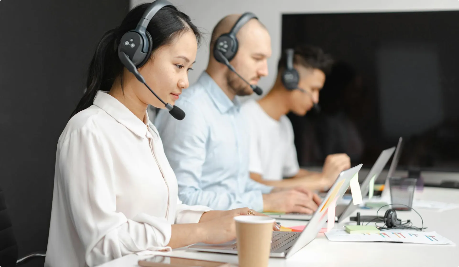 Healthcare contact-center professionals reviewing patient calls at their workstations