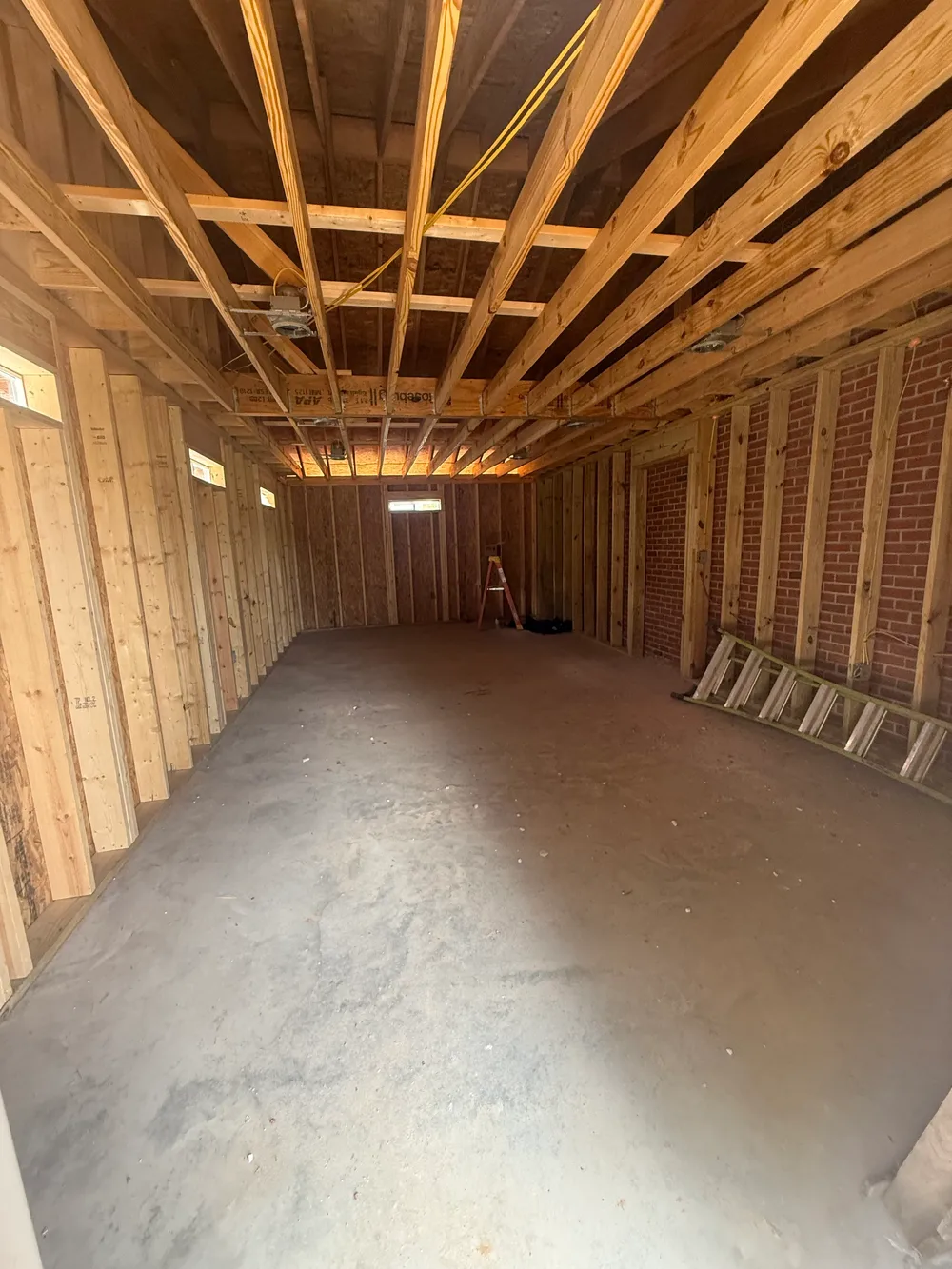 Exposed interior wall studs and ceiling joists in the gas-station addition