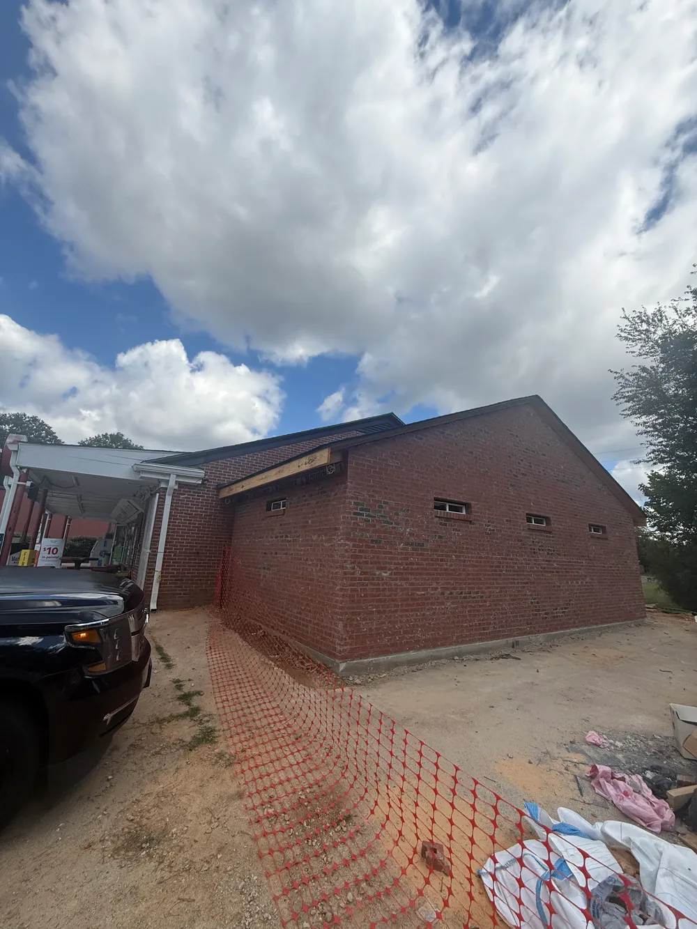 Closer exterior view of the brick addition with construction safety fencing