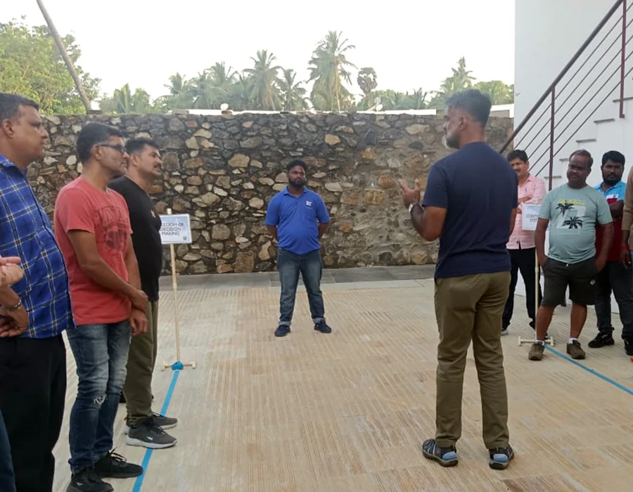 A facilitator briefs a group of participants outdoors before a leadership activity