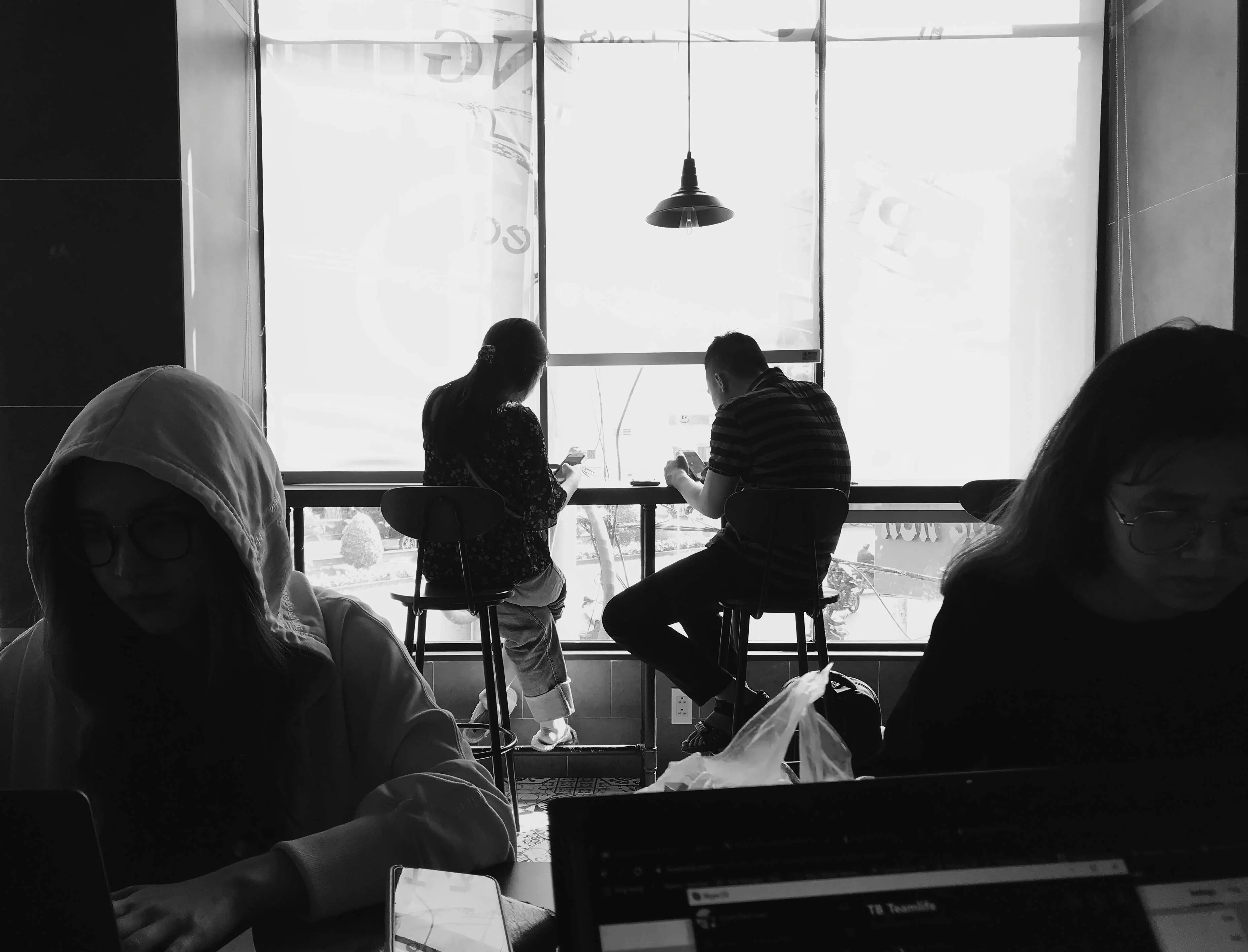 People working together beside a bright window
