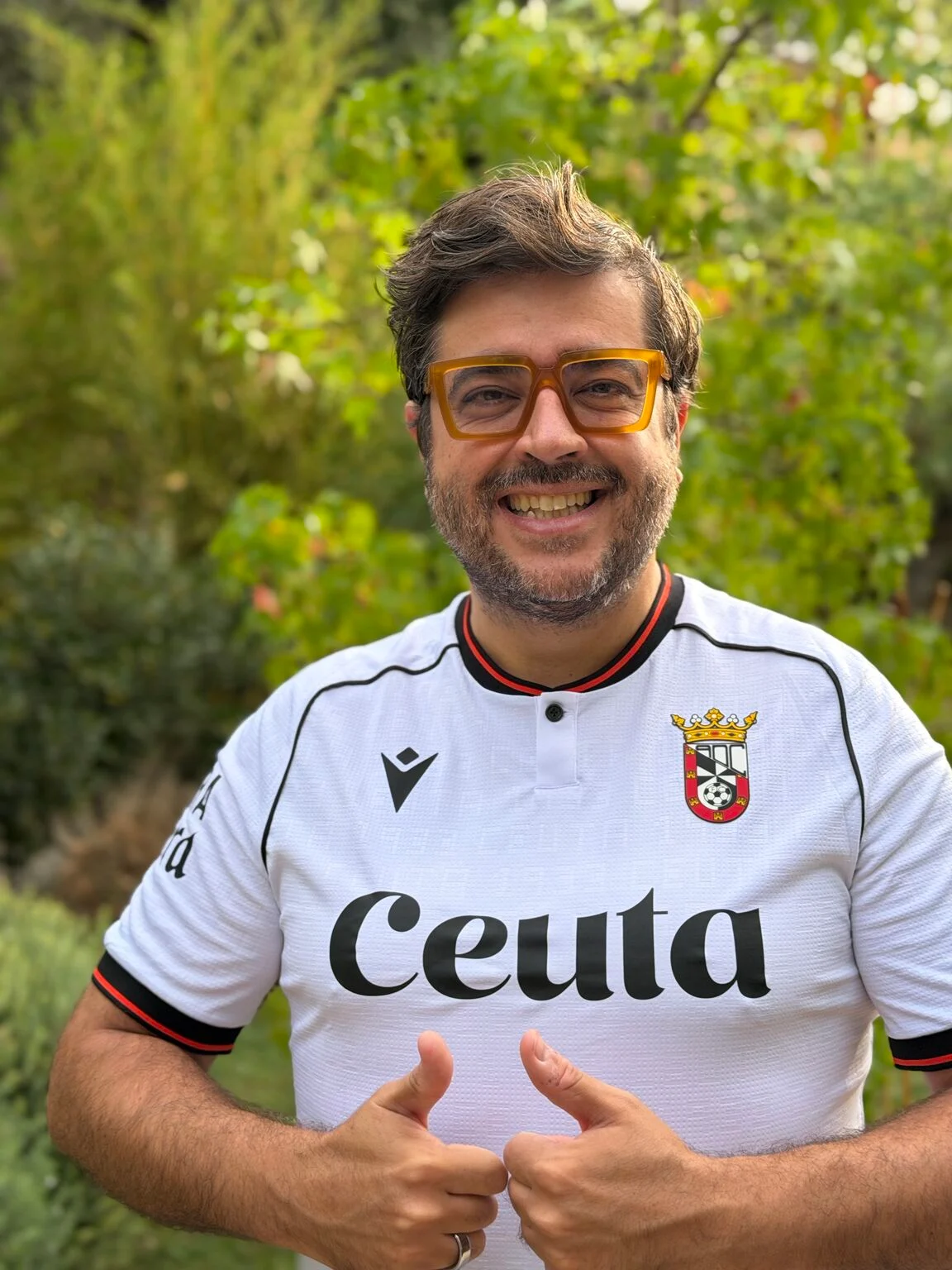 Rafael Tamames sonríe con la camiseta blanca del Ceuta y gafas amarillas.