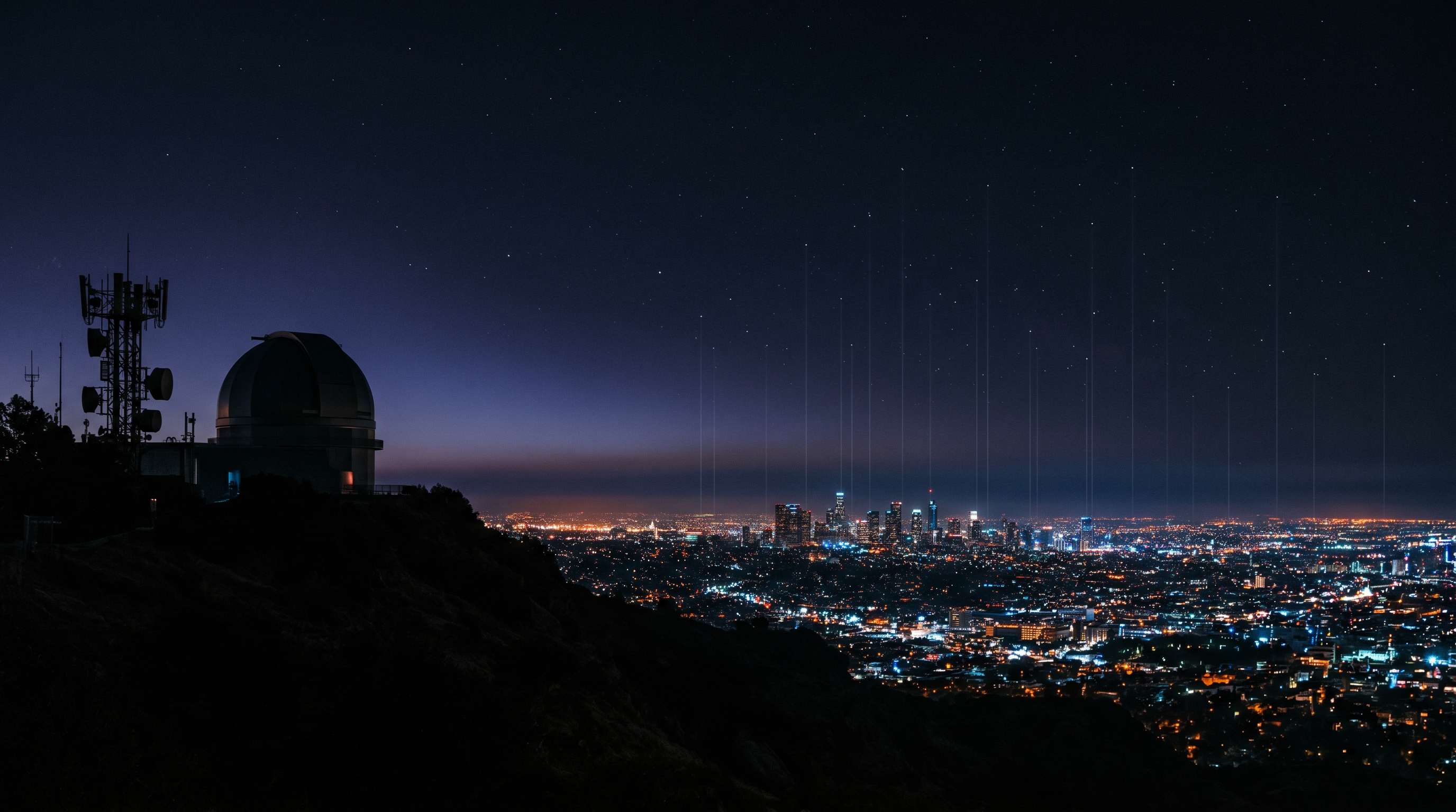 Hillside observatory dome silhouetted at dusk with a low city skyline and faint vertical light columns rising behind it