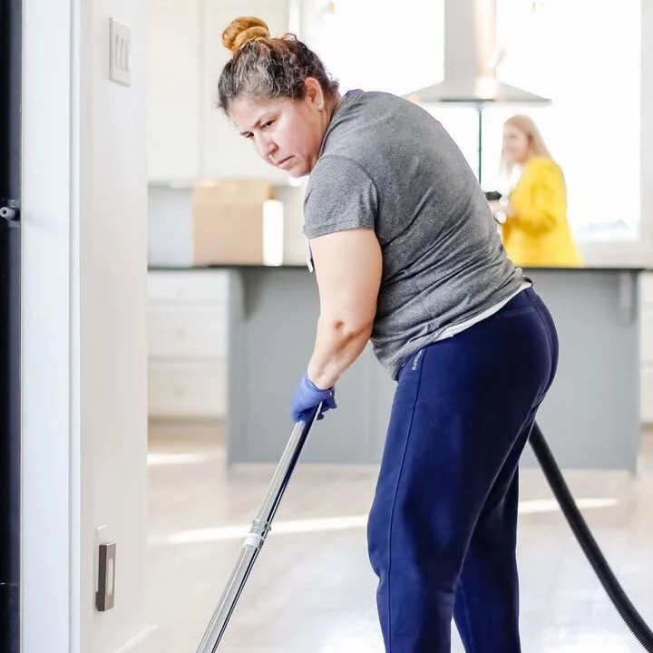Vella professional cleaner vacuuming a floor with reusable tools, showcasing zero-waste cleaning practices.