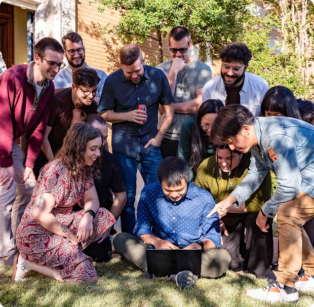 Coverbase team reviewing work outdoors around a laptop