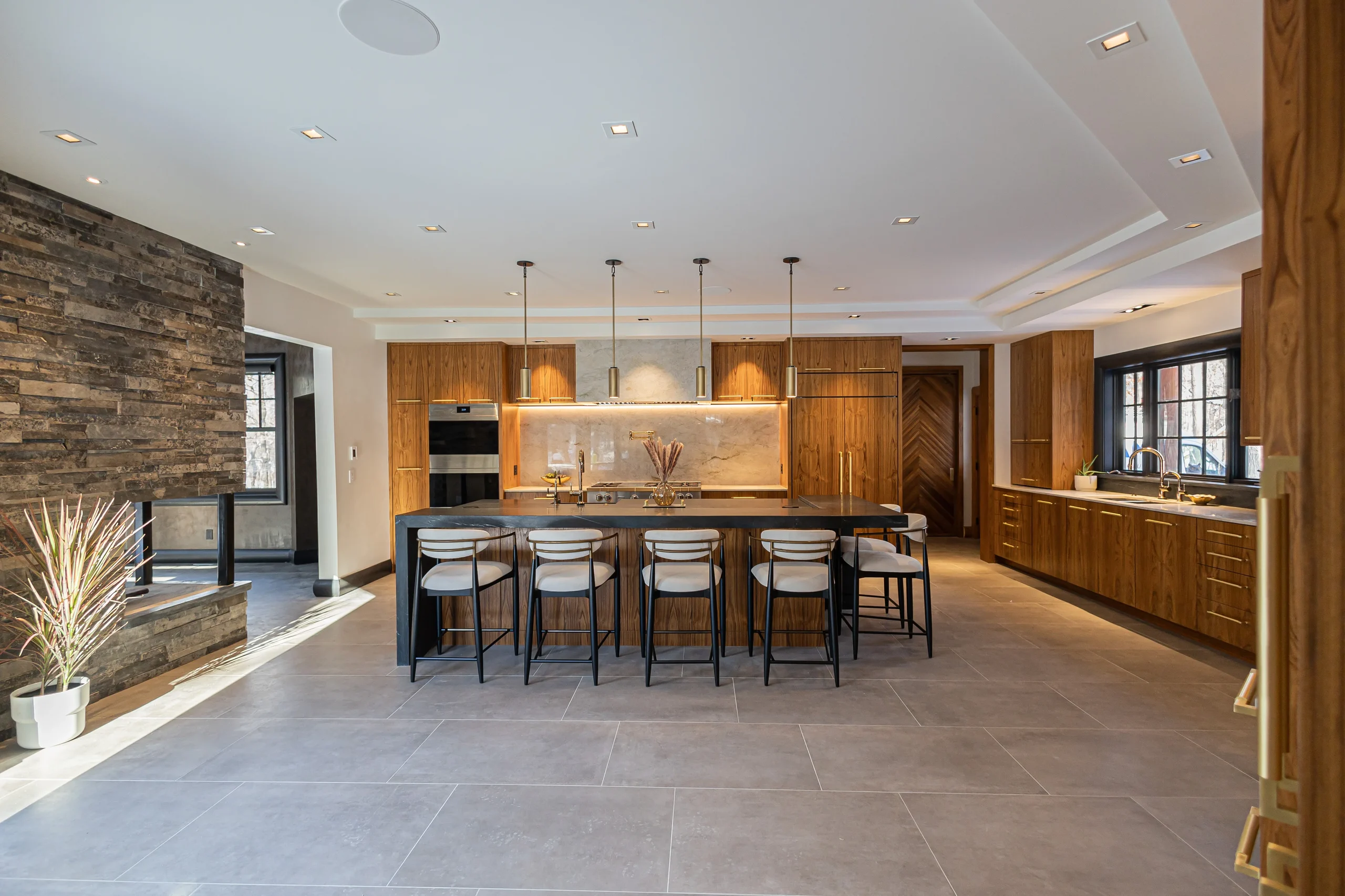Walnut kitchen and stone fireplace at Lake Shore Drive Residence