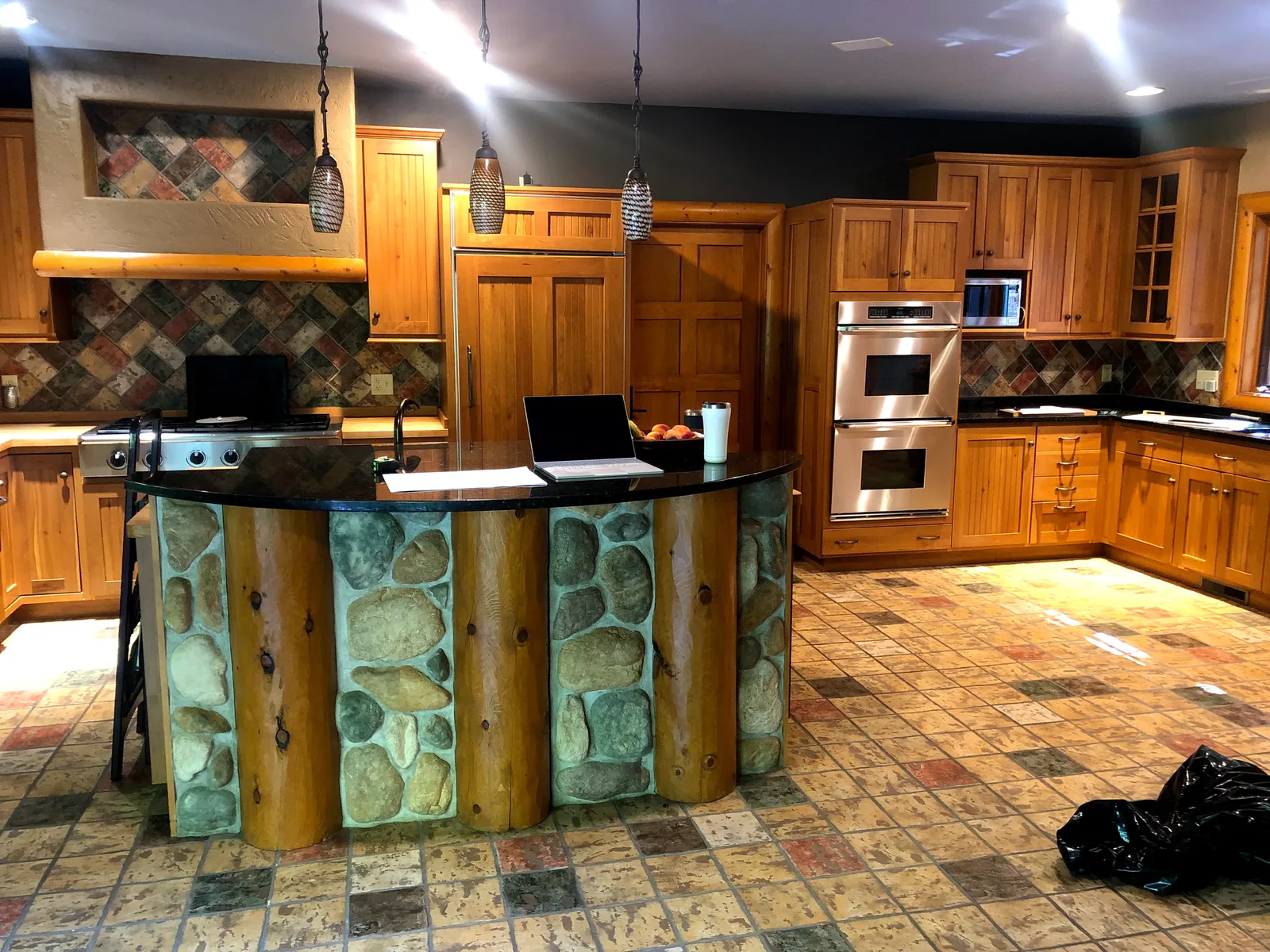 Original Lake Shore Drive Residence kitchen with wood cabinetry and a stone faced island before its transformation