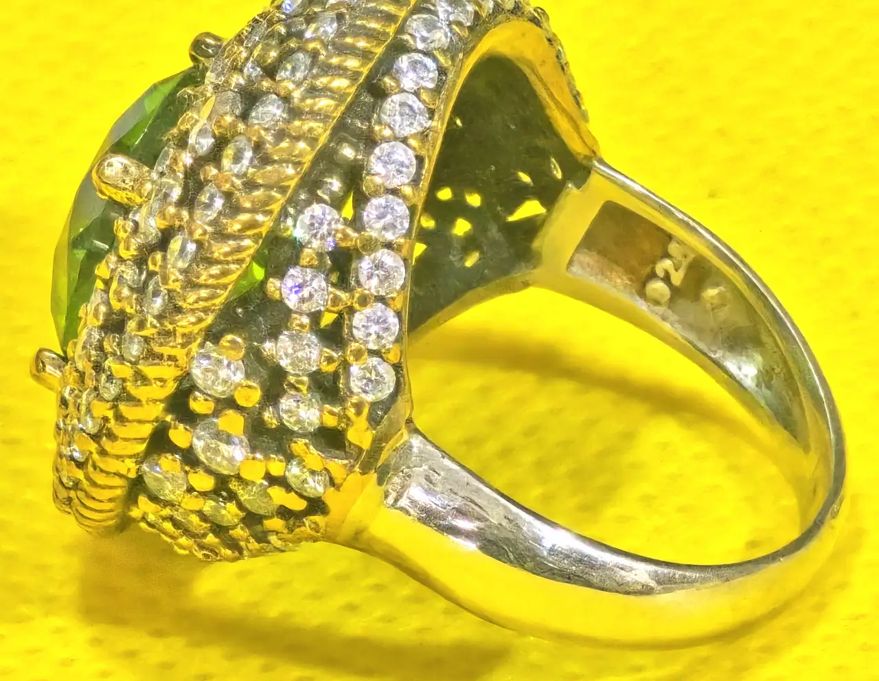 טבעת כסף 925 חתומה מידה 7\7.5 אבן מרכזית זו אבן פרידוט ומסביב אבני סברובסקי יש נגיעות של זהב