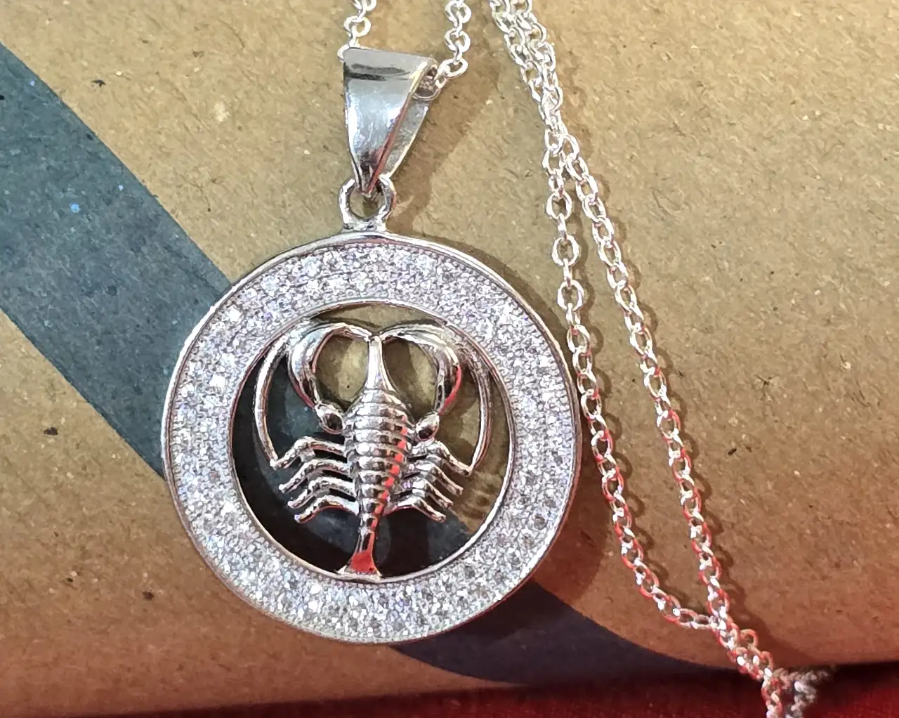 שרשרת כסף 925 עם תליון עגול המעוטר באבני זירקוניה קטנות סביבו ובמרכז דמות של עקרב ..תליון מזל עקרב