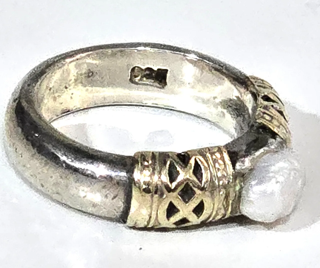 טבעת כסף 925 חתומה במרכזה פנינה לבנה ובצידי האבן נגיעות של זהב וינטג' יפה ואיכותית. מידה: 6 משקל: 8 גרם