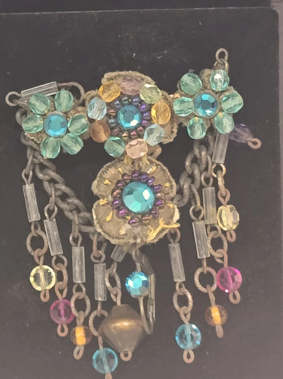 סיכה שהיא פריט אספנות סגנון וינט'ג הסיכה משובצת בחרוזים צבעוניים  הכוללת אלמנטים בצורת פרחים