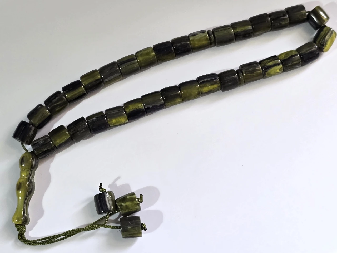 Tesbih מחרוזת תפילה איסלאמית מסבחה, טסביה, 33 חרוזי תפילה מסורתיים קלאסיים, עם מפרידים, מסתיימת ב"אימאם" (החלק המאורך בקצה) ו 3 חרוזים קינטיים. טסביח מחרוזת תפילה, מסבחה איסלמית, בעיצוב מסורתי, עם דיסקיות הפרדה כל 11 חרוזים. החרוזים עשויים דמוי אוניקס. אורך כללי 32 ס"מ. מצב מושלם.