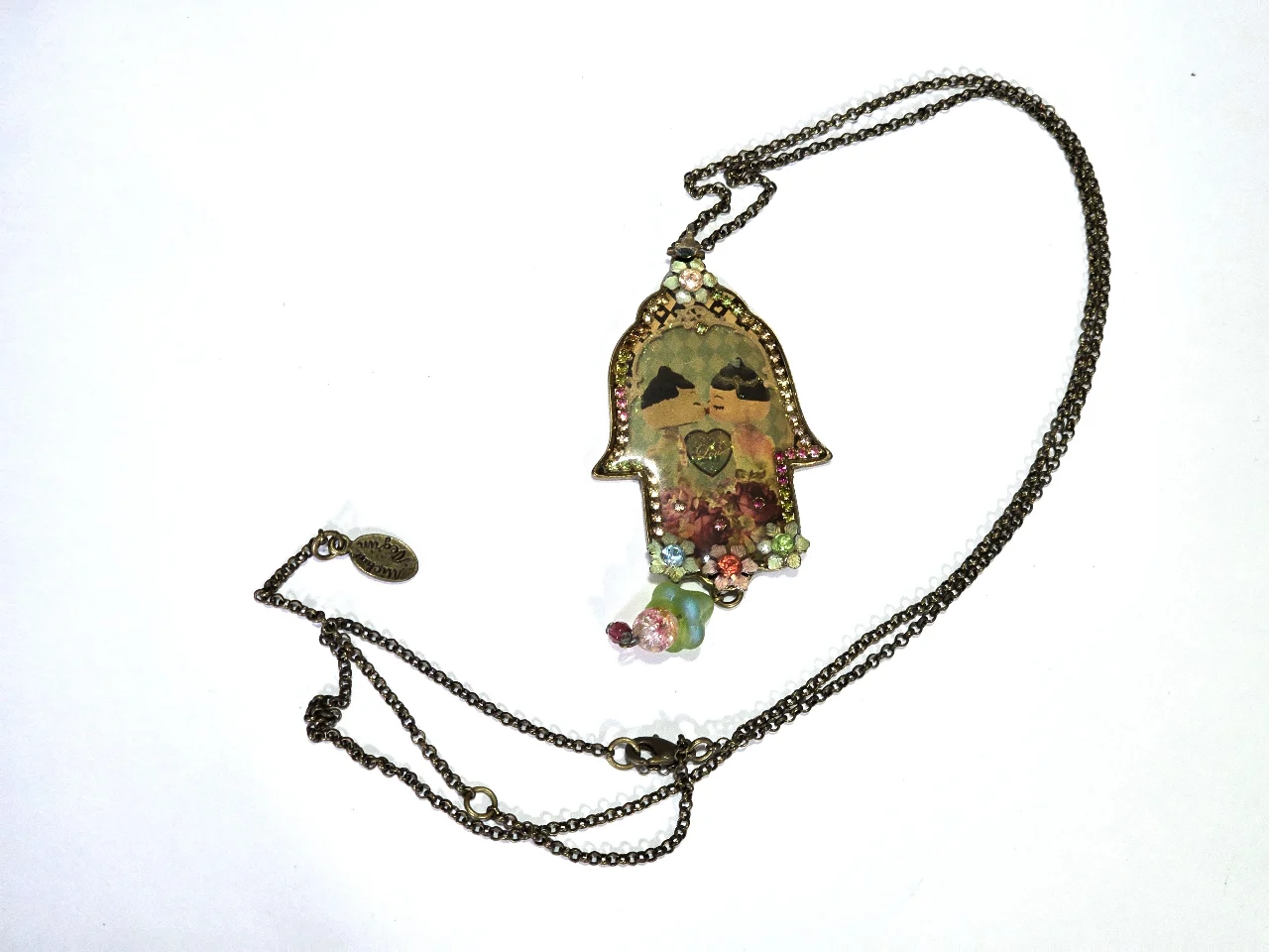 שרשרת עם תליון חמסה של מיכל נגרין התליון עם אמיאל מעוטר בפרחים אבני סברובסקי ובמרכז התליון זוג נההבים מידות בתמונות