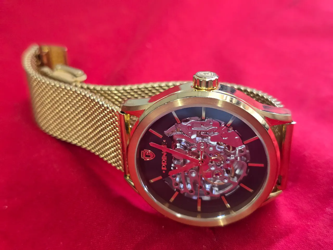 שעון יד לגבר עם מנגנון אוטומתי עם תנועת היד .ניתן לראות את גלגלי השינים של השעוןגוף השעון והרצועות בגוון זהב