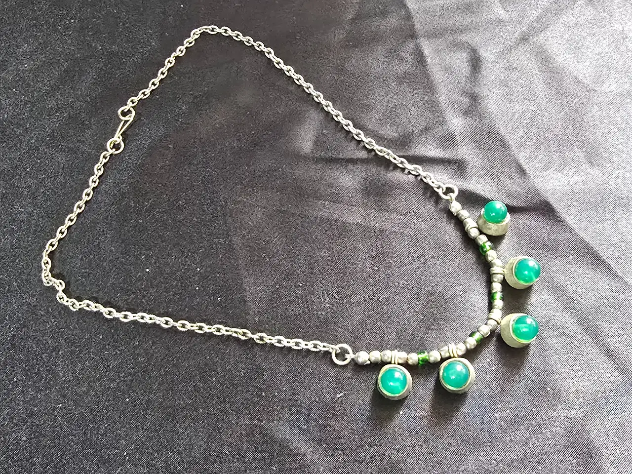 שרשרת חוליות כסופה (כסף טיבטי) ובמרכזה ישנם 5 תליונים עגולים בגווני כסף וירוק שהאבנים בתוכם קבושון ג'ייד סגנון וינט'ג מתאים לאספנים נוסטלגים