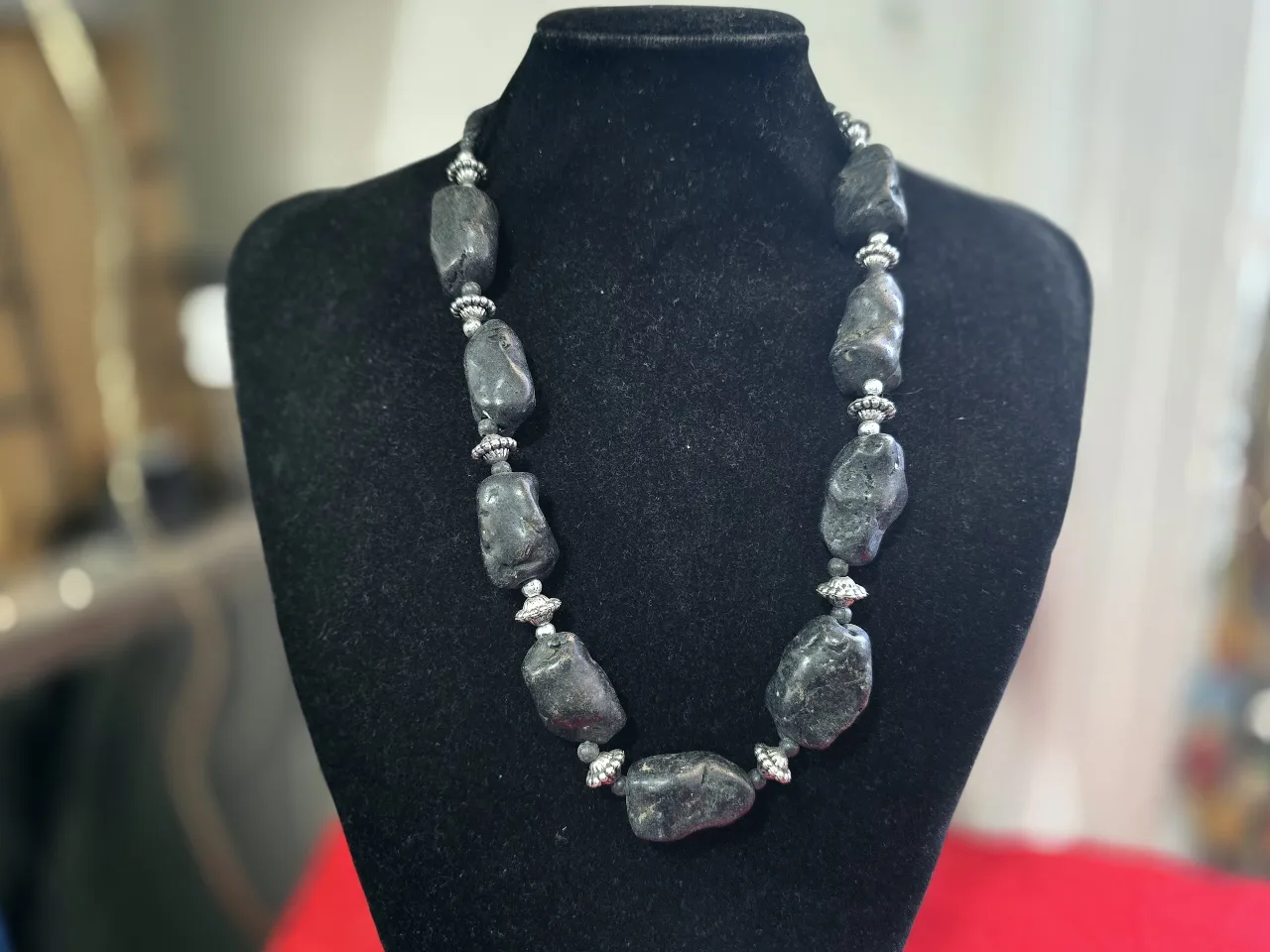 שרשרת מורכבת מאבנים שחורות גדולות וטבעיות המופרדות הנהם עם חרוזי כסף