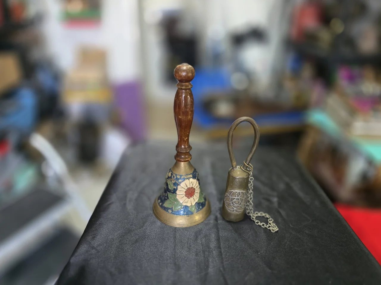 זוג פעמוני נחושת האחד עם ידית מעץ ושילוב אמייל פרחים והשני עם שרשרת   גובה: 14 ס"מ   גובה: 19 ס"מ