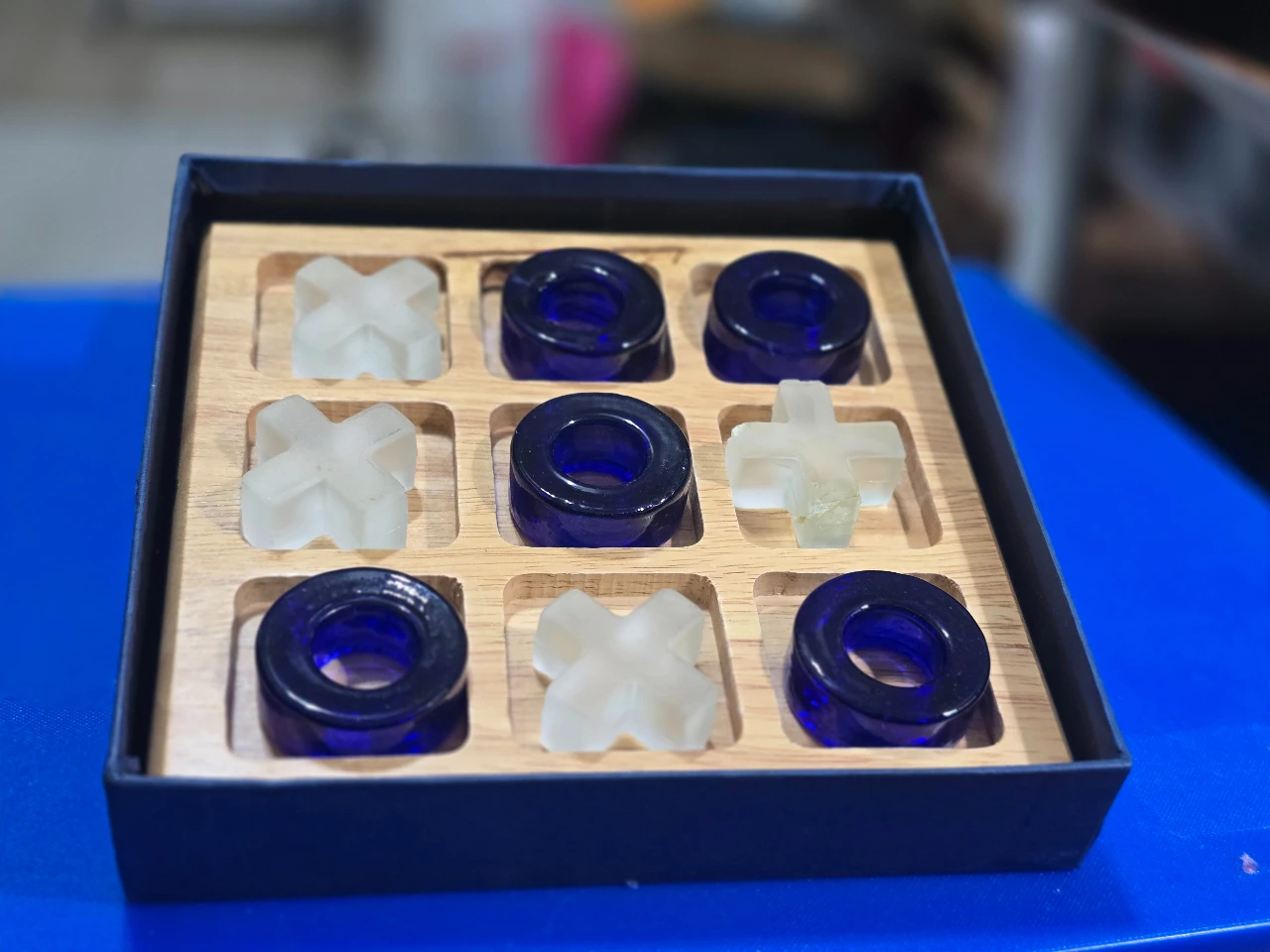 משחק איקס-עיגול (איקס מיקס דריקס) כולל לוח עץ וחלקים בצבעי כחול וקרם נתון באריזה מקורית