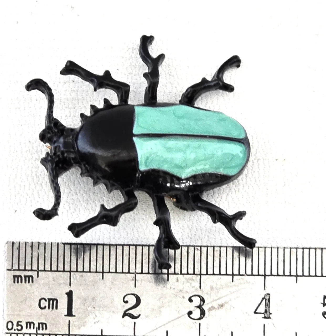 סיכת חרפושית - מתכת שחורה עם גב סברובסקי בצבע טורקיז אורך 3.5 ס"מ