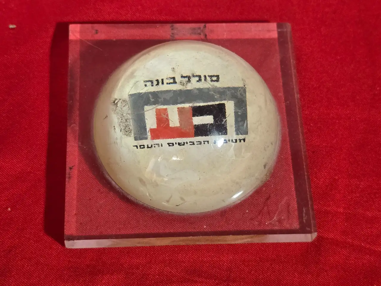 משקולת נייר שהיא גם פרסומת  סולל בונה  חטיבת הכבישים והעפר . תוצרת הצבי -  קיבוץ מעיין צבי . שריטות ...  מידה 9.5 על 9.5 על 4 סמ