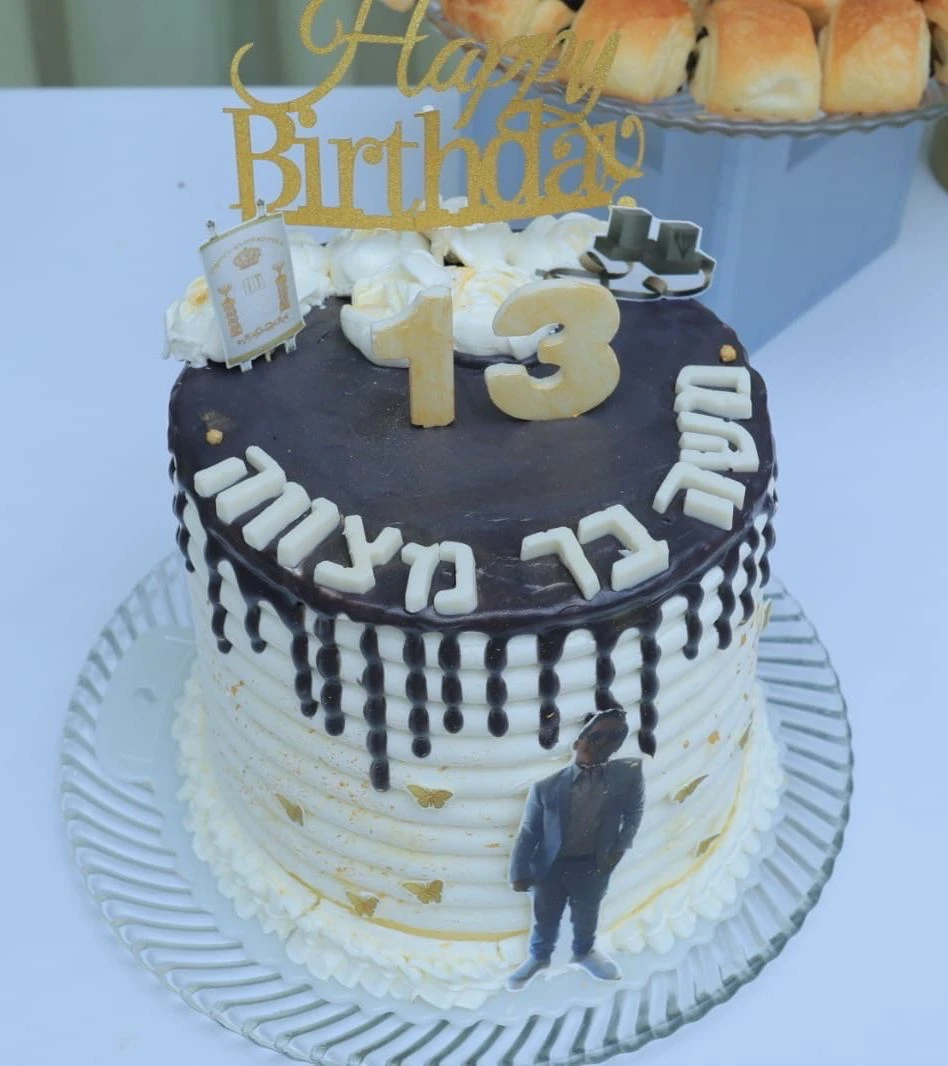 עוגת בר מצווה בעיטוף לבן מזוגג קלאסי ותמונה אכילה של החתן.