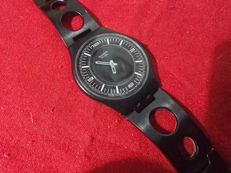 שעון יד קוורץ תוצרת סווטש Swatch שוויץ, AG 1999 Skin Noir, רצועת מתכת עם תוספת בצד להרחבה, נתון בקופסא מקורית, מצב טוב מאוד אבל יש צורך להחליף סוללה