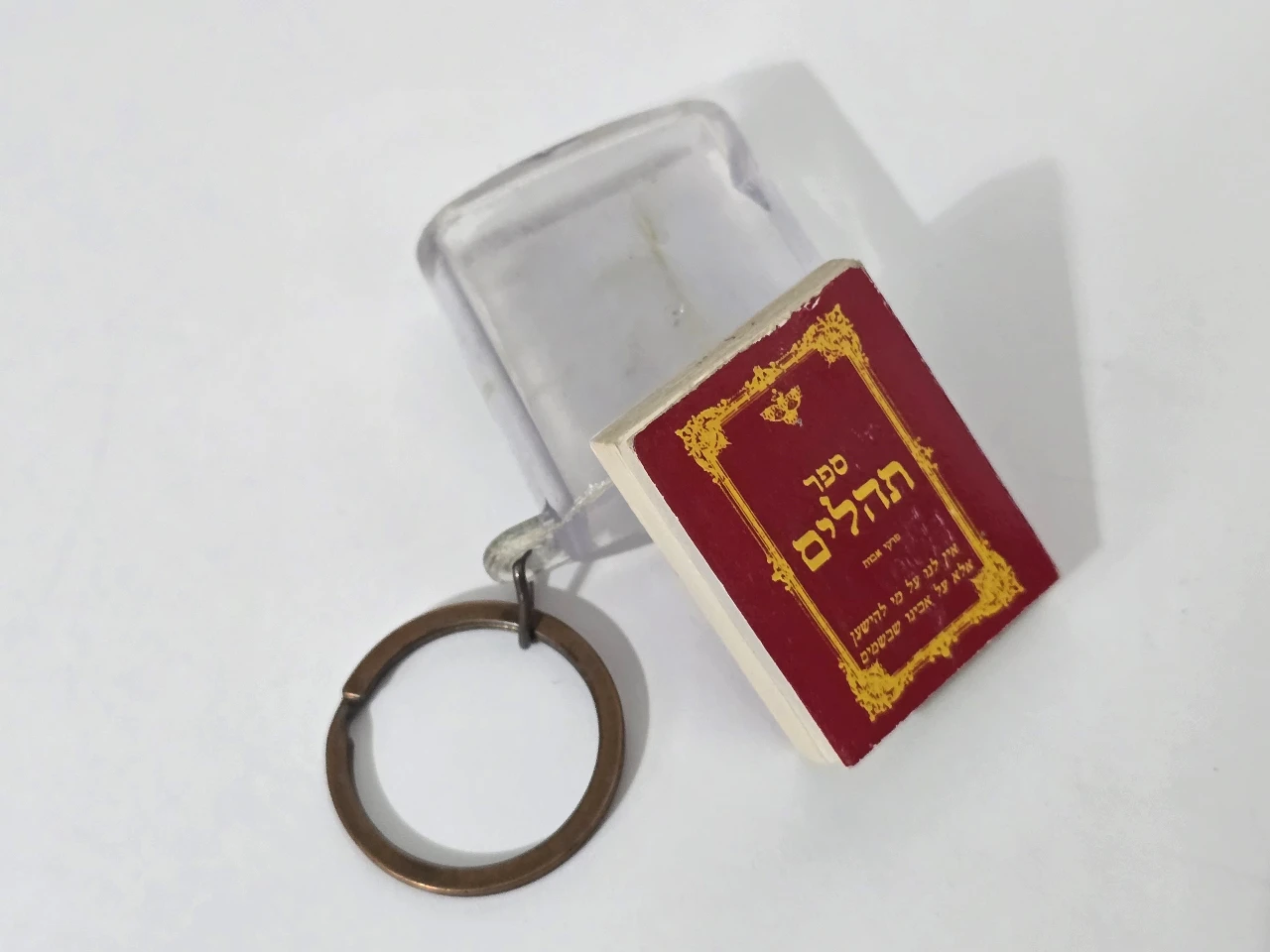 מחזיק מפתחות עם ספר תהילים מונח בקופסת פלסטיק