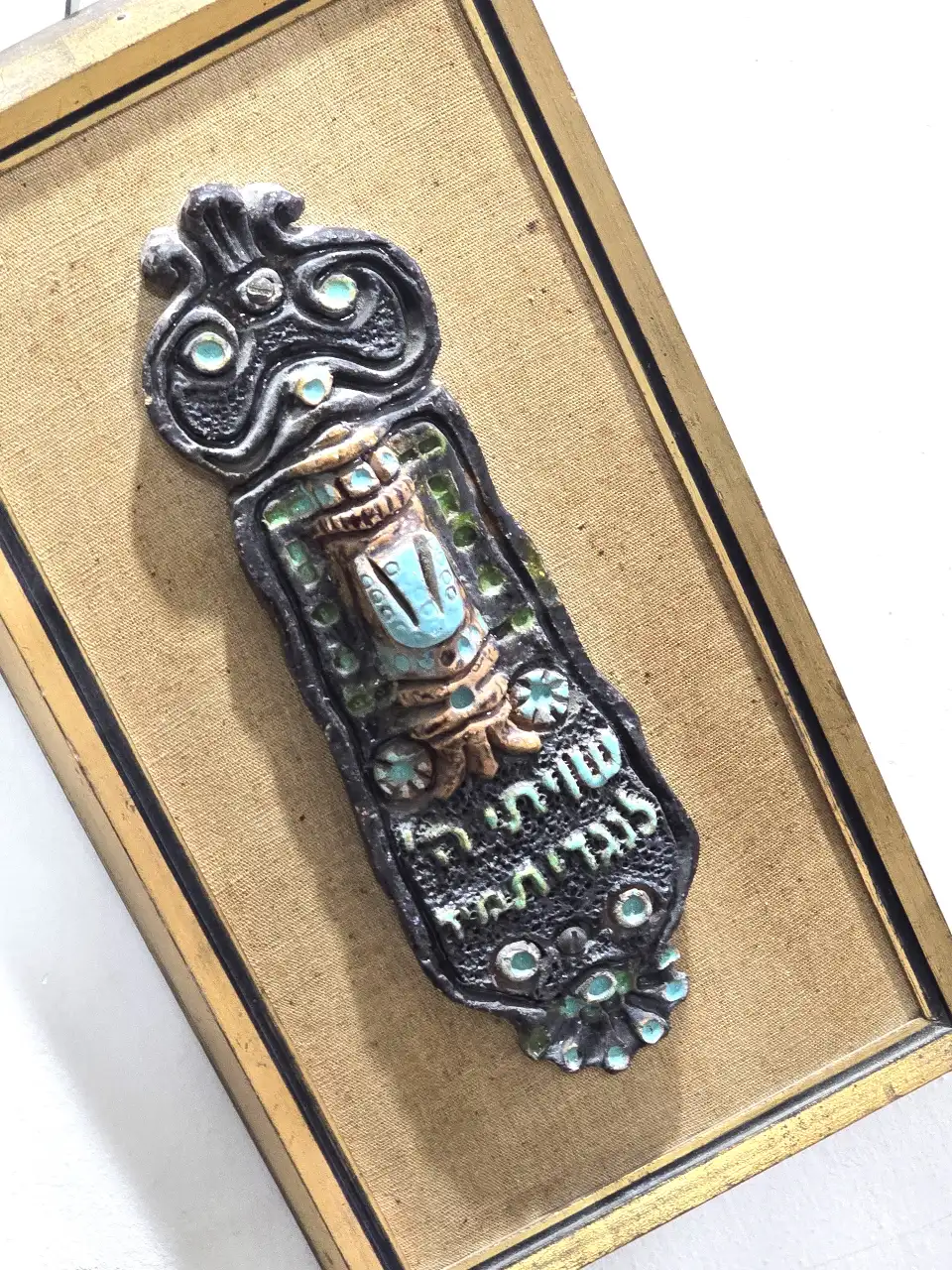 בית מזוזה גדול נתון במסגרת עץ כנראה קרמיקה בשילוב אמייל מידות 32*17