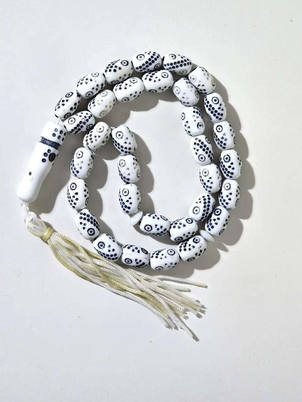 מסבחה מחרוזת תפילה בעיצוב יחודי עם חרוזים לבנים ועלהם דפוסים שחורים קטנים המחרוזת כוללת 33 חרוזים