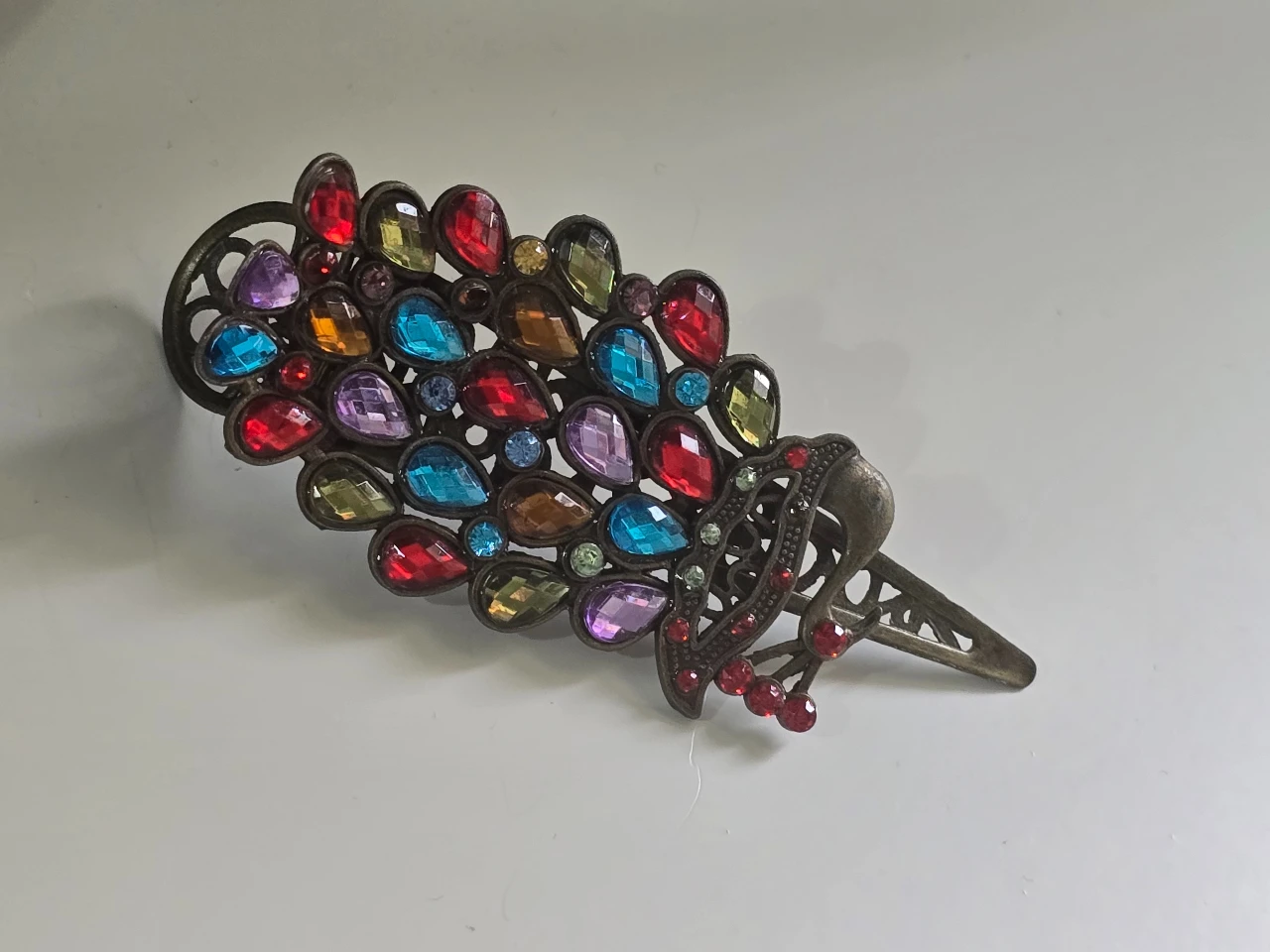 סיכת שער מעוצבת בצורת טווס עם אבני חן צבעוניות