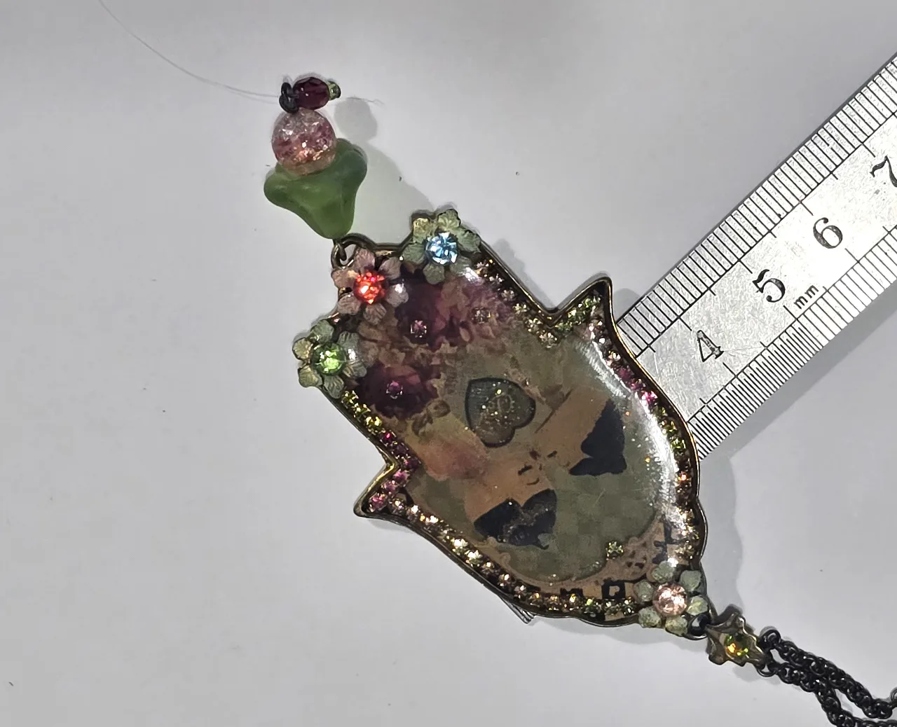 שרשרת עם תליון חמסה של מיכל נגרין התליון עם אמיאל מעוטר בפרחים אבני סברובסקי ובמרכז התליון זוג נההבים מידות בתמונות