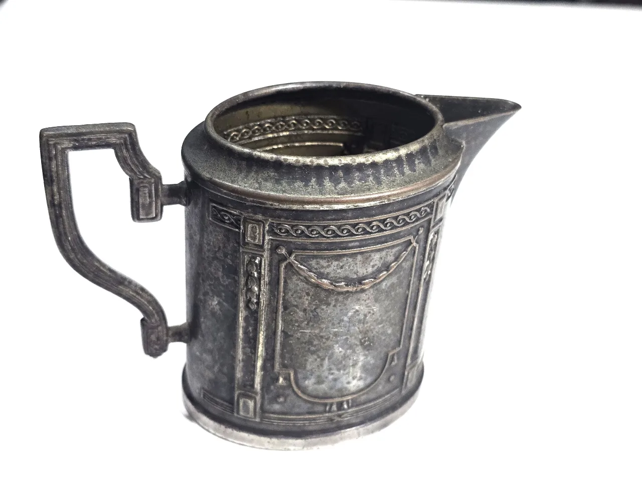 Creamer קנקן / כד חלב אירופאי עתיק, עשוי פיוטר מצופה כסף, עם תבליטים אופיניים לתקופת מאה 19   מצב שמור, עם פטינה טבעית.   גובה - 10.5 סמ   בסיס - 8X6 סמ