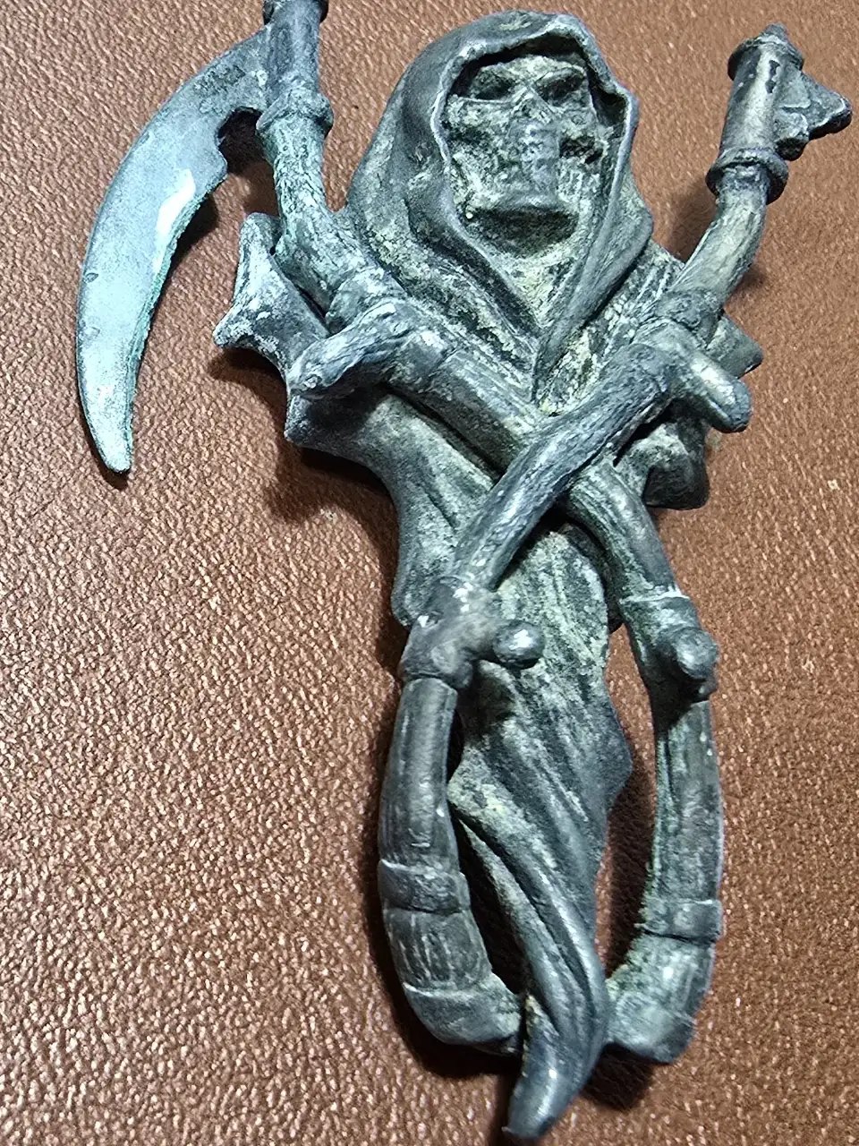 תליון מראה דמות נשית מביטה אל תוך המראה עשוי מפיוטר והדמות השניה מלאך המוות