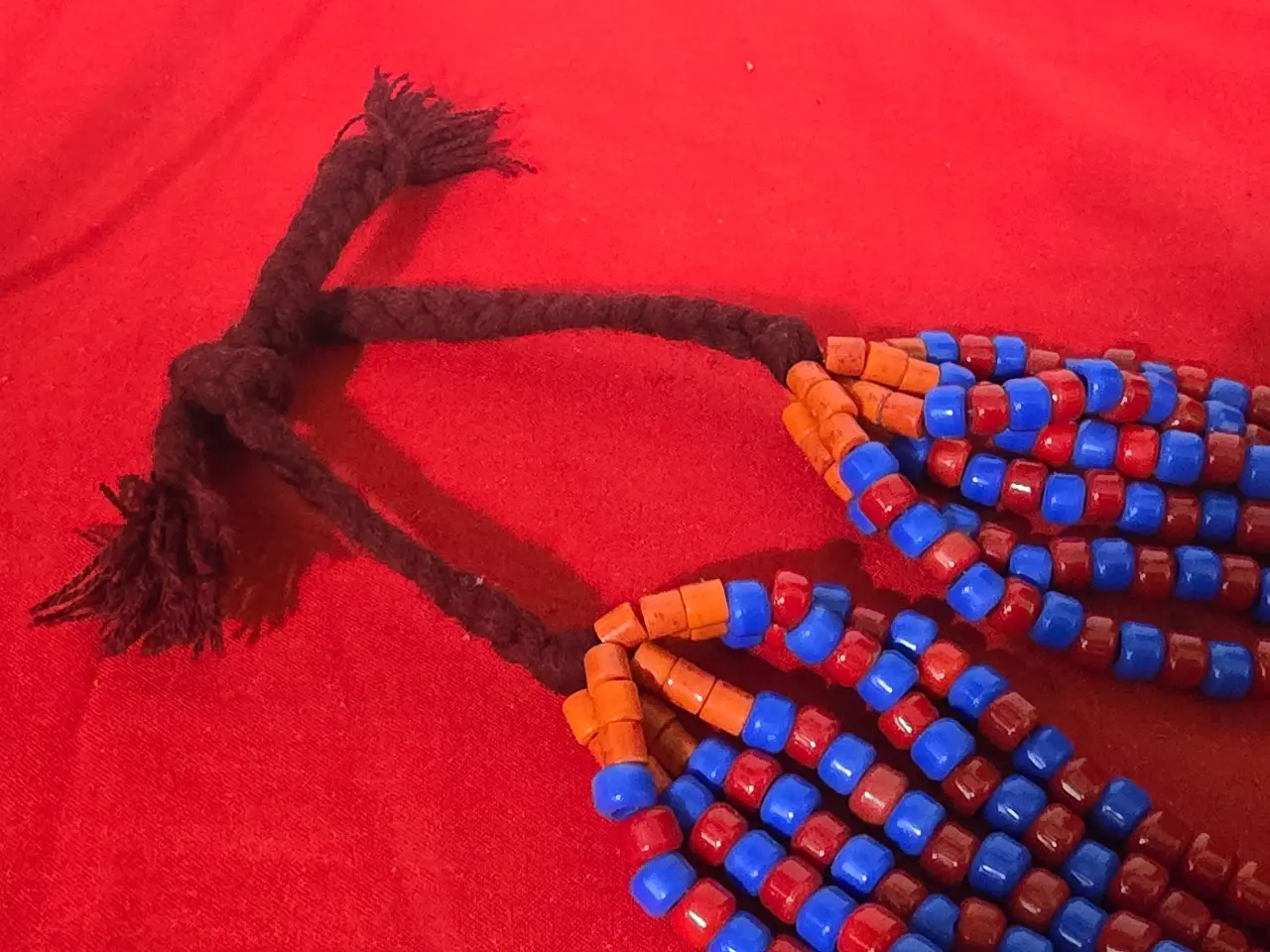 שרשרת תכשיט מרשים בסגנון אתני טיבט נפאל או צפון אפריקה השרשרת מורכבת מריבוי שורות של חרוזים קטנים בצבע אדום וכחול עזים חרוזי טורכיז בחלק התחתון