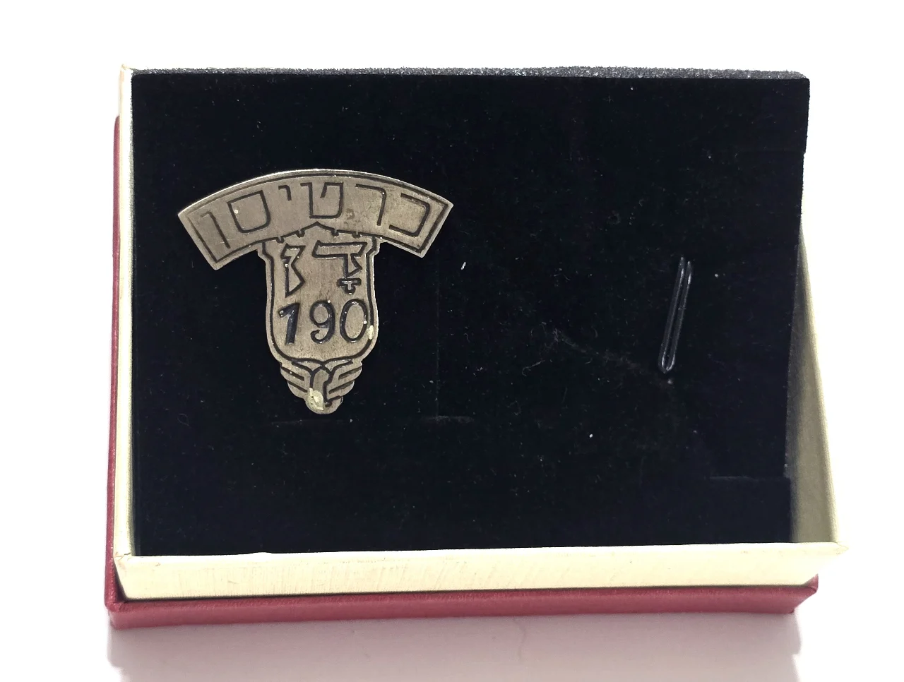 סמל כובע מוקדם כרטיסן בחברת האוטובוסים דן משנות ה-40. פלדה. מספר 190. מידות כ 32x32 מ״מ