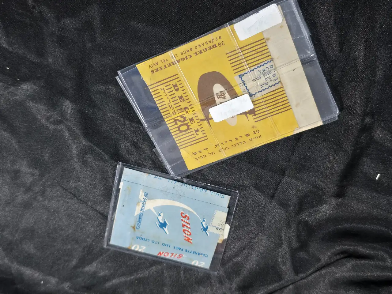 לוט 2 אריזות טבק ישראלי: 1. אריזה לסיגריות מזרחיות "סילון", בית חרושת לסיגריות לוד. 2. אריזה לסיגריות דגל, אחים בז'רנו תל-אביב.
