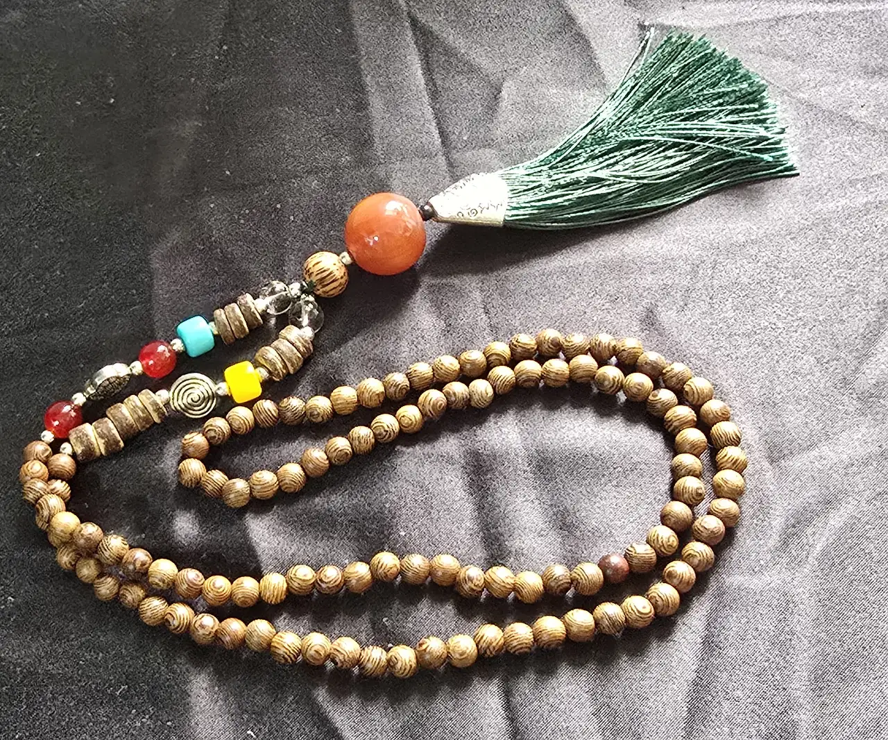 שרשרת עם 108 כורים קטניםפ וחומים בתחתית יש אבנים צבעוניים ואלמנטים  של מתכת לפי איפיון השרשרת  זאת שרשרת תפילה ומדיטציה נפוצה בתרבויות המזרח