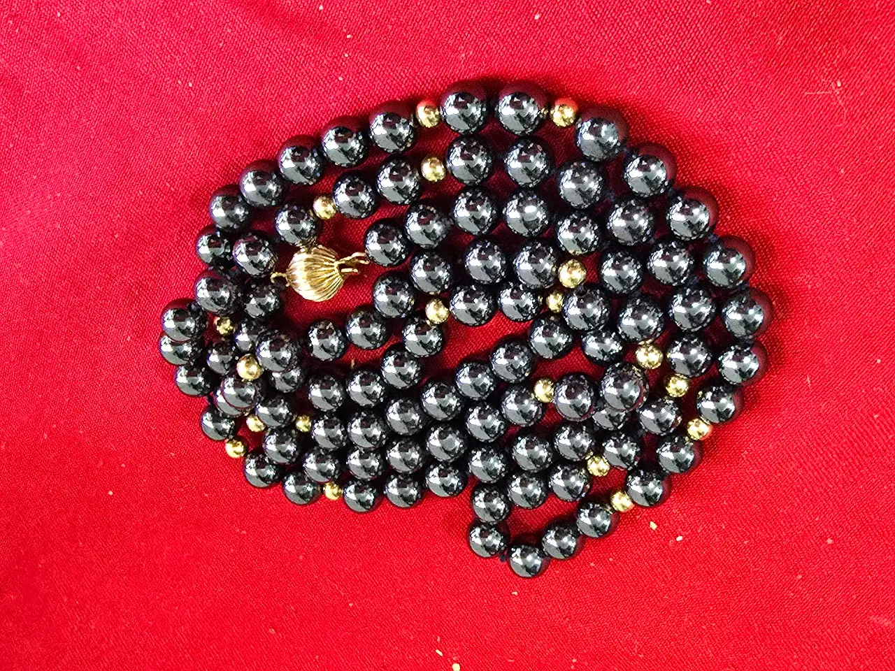 שרשרת המכילה אבנים טבעיות שחורות וחרוזי זהב קטנים